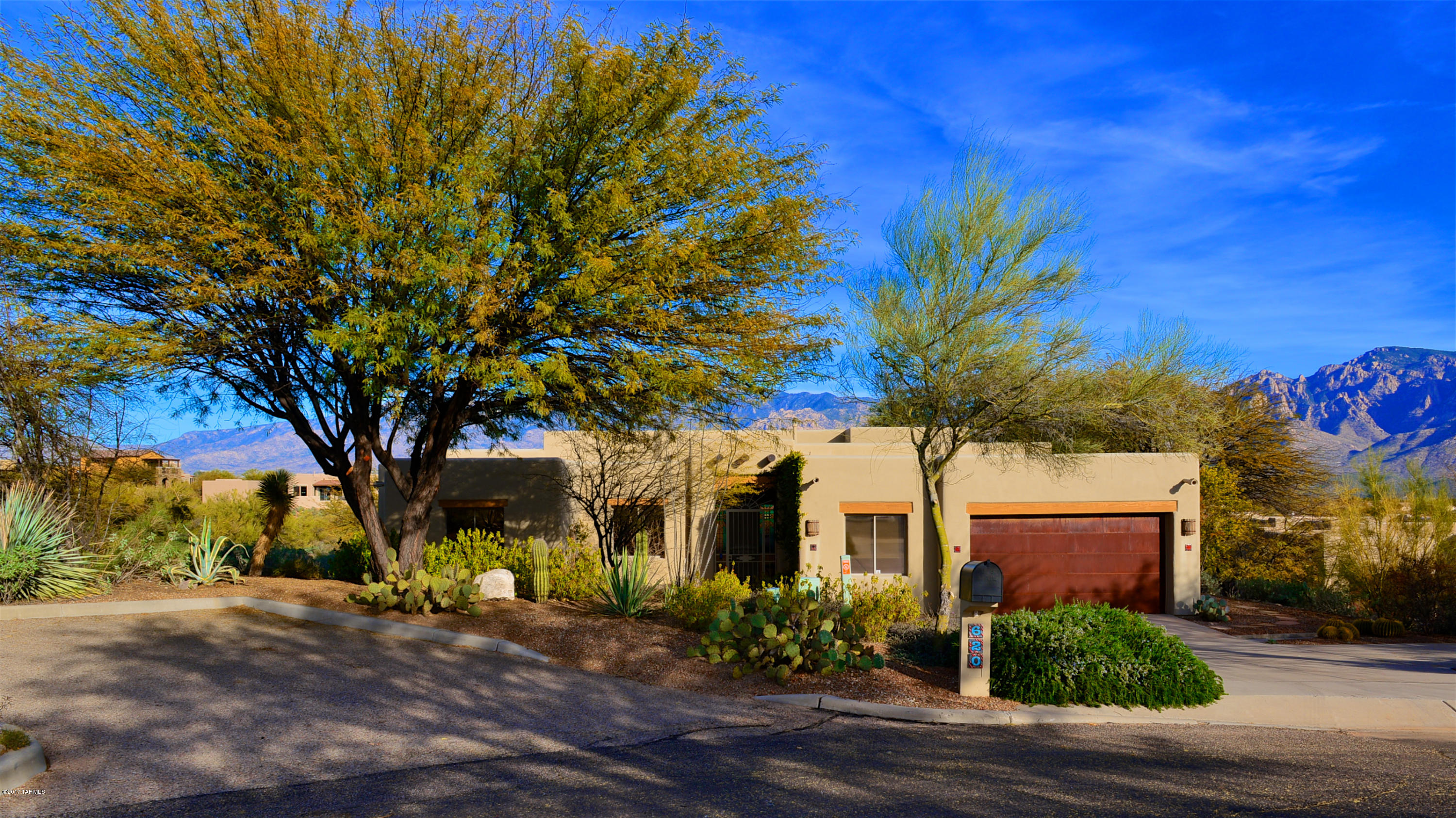 Gaze upon the breathtaking Catalina Mountains while relaxing on a Brazilian hardwood deck cantilevered over extensive dedicated open space, in a desirable Oro Valley subdivision. This custom built home w/ 3bd/2.25ba plus den features a wall of windows to maximize the spectacular mountain views, a formal living/dining room, family room & an open kitchen w/knotty alder cabinets, large pantry, breakfast bar & built-in cabinet style refrigerator. Attention to esthetic detail shines throughout, w/desert style Saguaro accents, wood corbels, stained glass panels, knotty Alder doors, Viga beams & Cedar wood ceiling. Retire to the master suite complete w/mountain views, private access to the covered patio & an ensuite featuring walk-in closet w/built in custom cabinets, tile shower & soaking tub. Spacious garage features an attached work/storage room!
