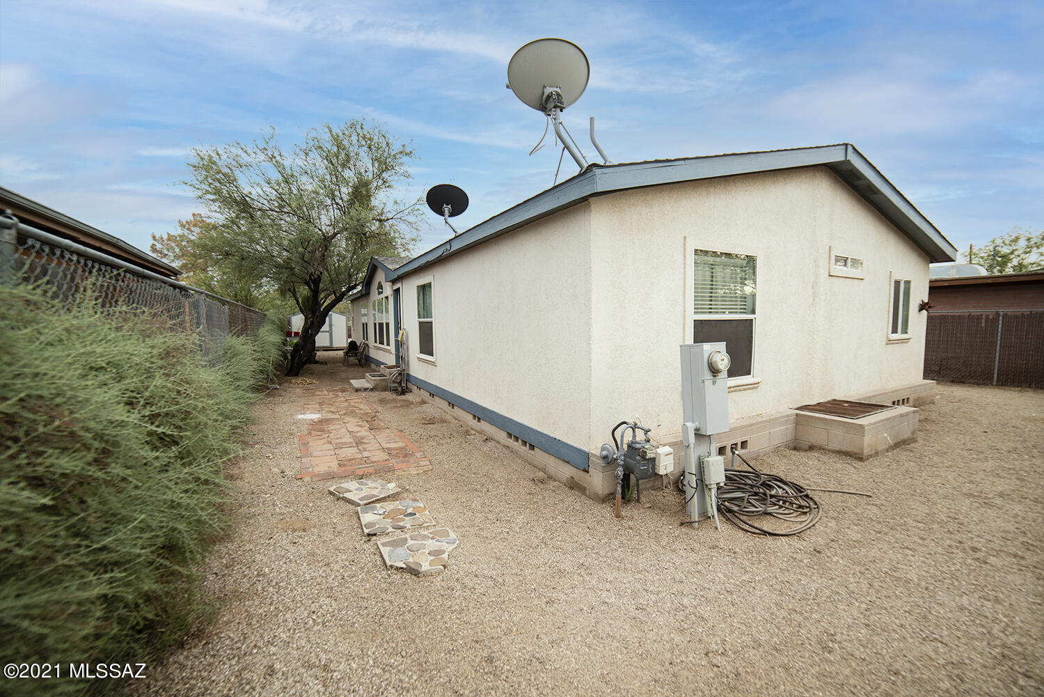 FOREEEEE You? Enjoy this home in Westside Tucson who's back yard looks into the El Rio Golf Course.  This Manufactured home has 2 Master Bathrooms, yes 2 and huge walk in closet that separates the two. Large living area and kitchen separate the Master from the 2 other bedrooms.  Huge yard for all your fun and INCLUDES 2 Large SHEDS