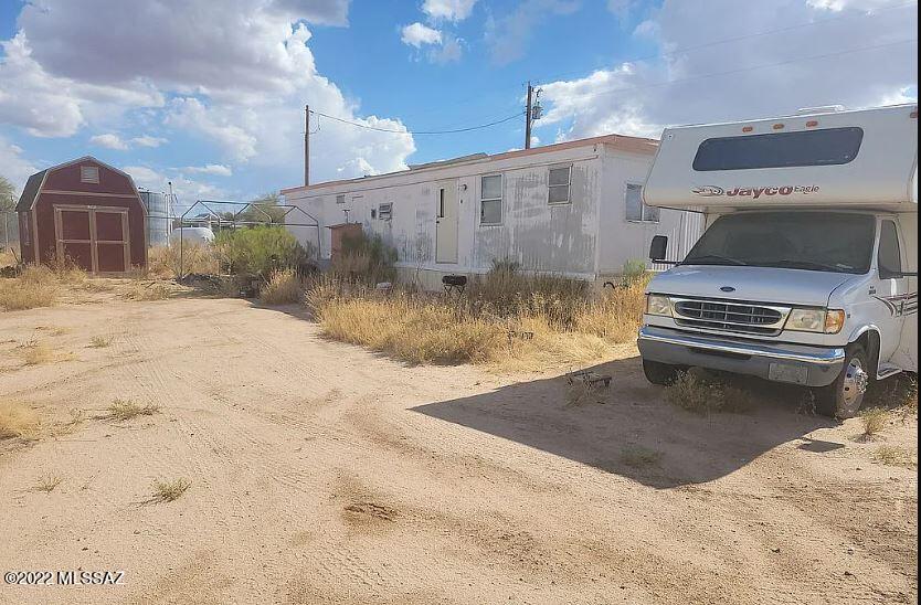 Grab it while you can! 1.27 Acres with beautiful desert landscaping & mountain views! Close to Blacktop. Comes with utilities, shed, junk mobile home and motorhome.
