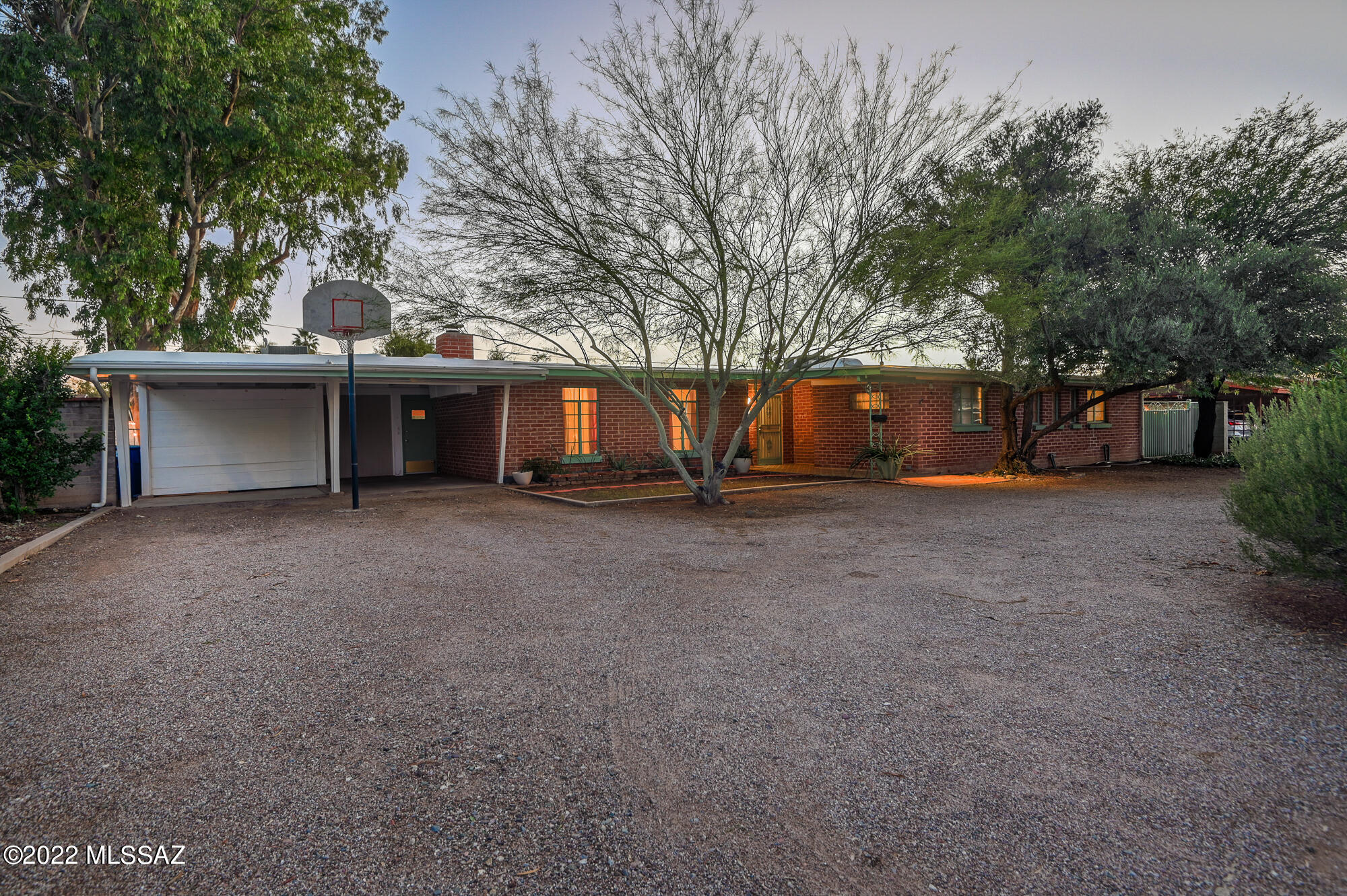 Meticulously maintained, classic mid-century double brick ranch style home in historic and desirable Broadmoor neighborhood.  Truly a delight to live in this home where natural light abounds, open living concept, gorgeous handmade beehive wood burning fireplace and wood beams and ceilings throughout.  The spacious and bright kitchen offers floor to ceiling cabinets with built-ins and a fully functioning vintage gas stove. Two primary suites with gorgeous vintage tile bathrooms, additional guest bedroom and guest bathroom with skylight and gorgeous vintage tile and glass, separate artist's studio or home office with Saltillo tile & built-in shelves.  Flexible dining room space with large energy efficient windows to the yard, and original vintage encaustic tile. Dual heating/cooling, 1 new AC and water heater, and both under warranty.  Low maintenance front and back yard on drip system with room for a pool or spa too!  Walk/cycle to great restaurants (Barrio Bread), shopping, entertainment, U of A, Reid Park and Zoo, and Downtown. Welcome to your move-in ready home.  West side primary bedroom has potential for (airb&b). Historic property tax benefits. Come see for yourself!