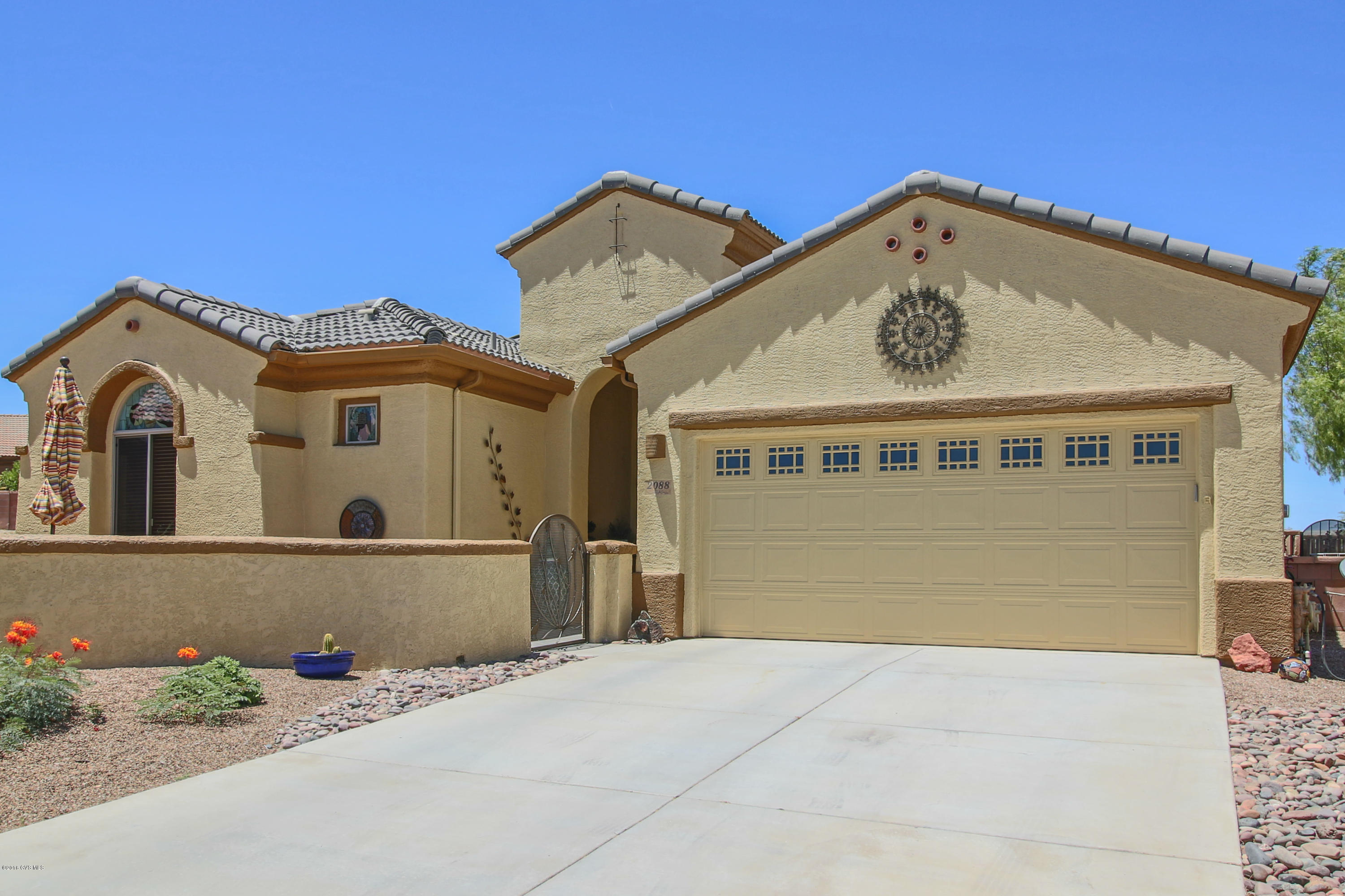 Welcome to a unique designer home nestled in a quiet cul-de-sac in the gated community of Canoa Ranch Terrace. Enjoy a beautiful mountain view from the enclosed front courtyard, and notice the fresh exterior paint (Feb. 2016) and gutters. As you enter, you'll find built in bookcases, stained glass windows, all tile floors and custom window treatments. This open, split floor plan has two master suites and a den. The kitchen has granite counters and a large granite sink, black and stainless appliances including a wine cooler. Both master suite bathrooms have natural stone vessel sinks. Outside you will find two more patios, one with a built in outdoor kitchen and a fire pit, the other covered by an aluminum pergola. Beautiful artificial turf completes the backyard oasis.