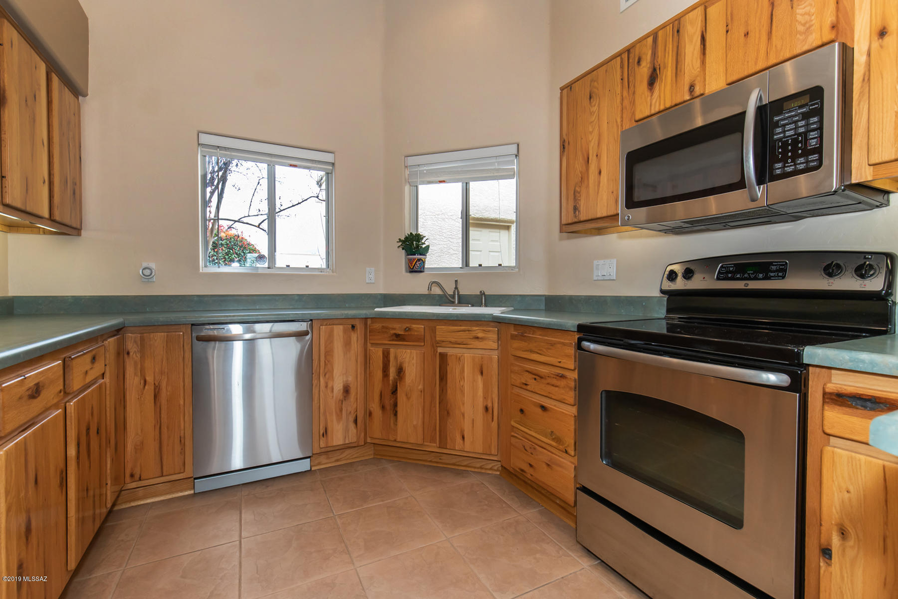 Fantastic opportunity for this IMMACULATE, move-in ready earth tone townhome with no wasted space in this functional 2 bed, 2 bath plan with large great room.  Kitchen boasts rows of knotty pine cabinets w/ underlighting, STAINLESS STEEL APPLIANCES, convenient space for desk.  CERAMIC TILE THROUGHOUT traffic areas and warm carpeting in bedrooms.  Dining area includes chandelier.  SPACIOUS MASTER BR with double mirrored closet sliding doors and view to back porch, mature tree. CEILING FANS throughout, incl COVERED back patio.. every window has blinds.  Sspeakers in LR wall/ceiling and patio.  CLUBHOUSE POOL/REC CENTER. Pre-wired for security alarm, Internet, cable. Front loading washer.  Garage has ample space for 2 cars; shelving and work bench stay.