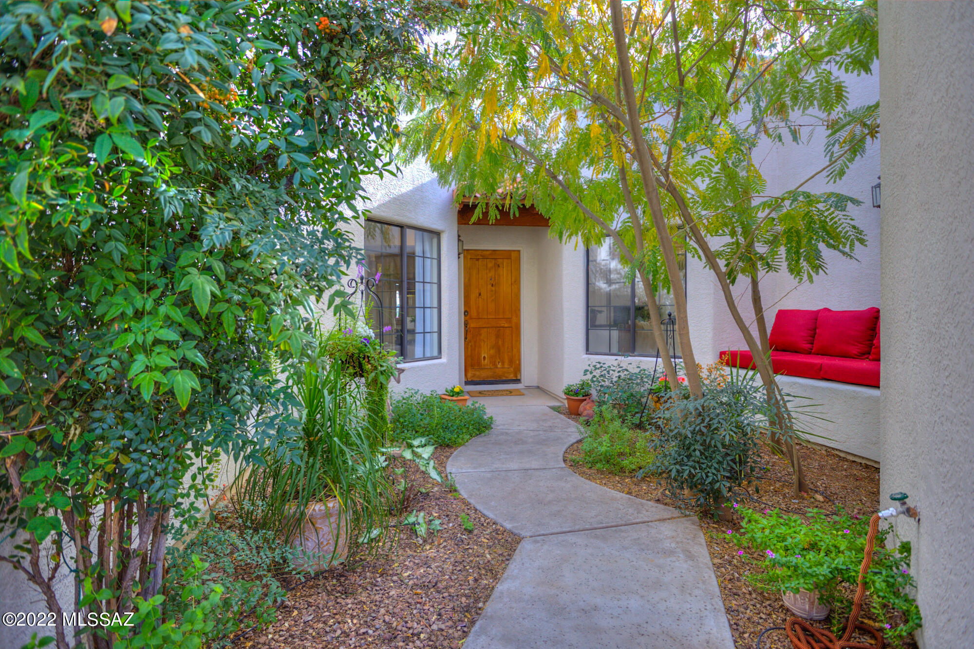 Easy to love this charming remodeled 3 bedroom home in small  northwest neighborhood.  Rare steel framed construction home located on  a corner walled lot for privacy.  Inviting courtyard entrance to this amazing home.  Great room w/high ceilings and fireplace opens to newly remodeled kitchen w/center island, new stainless steel appliances, gas range, solid European walnut countertops. Split bedroom floor plan, stained concrete floors throughout much of the home. Wrap around patio, newly landscaped low maintenance backyard w/artificial turf, several citrus trees, raised flower/garden beds, all on drip irrigation. 2 car garage w/builtin cabinetry. New HVAC 2020, new hot water heater, exterior paint and roof recoated in2021.  Must see, this home is a treasure.