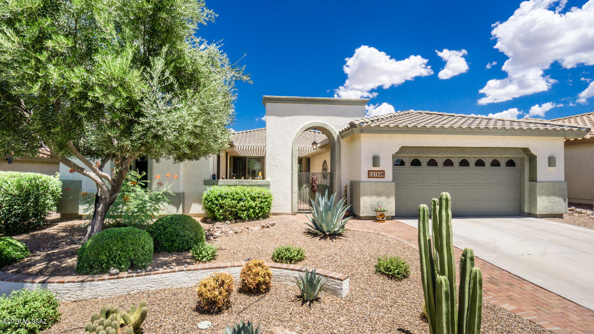 Contemporary yet with Southwest flair! The ambiance begins as you enter the private front courtyard finished with tumbled brick and low care pergola. Through the front door is an expansive open floor plan with a wall of windows overlooking the back yard - the great room and dining area flow together and are finished off with a coffered ceiling.  Flooring is low care wood laminate. Artistic paint and ''brick'' touches to archways and recesses add to the charm of this home. The kitchen is finished with engineered stone counter tops in a neutral color, complementary tile and lower cabinets have double roll-out shelves. The master suite is entered between double doors to a foyer; the dual bath vanities are finished with marble and the oversized shower has a seat and custom tile; a 9 x 15 walk-in closet is off the bath; the bedroom is large with windows overlooking the private back yard (windows have solar screens). Across from the master suite is the large den - a perfect getaway spot to use the computer or just relax with a book.  Your guests will feel pampered with the inviting bedroom and bath (walk-in closet in bedroom).  For overflow guests there is a separate entrance casita equipped with microwave and mini-fridge. The roof, water heater and drip system are less than 3 years old, the garage has been expanded 2 feet in length and has a wall of built-in cabinetry. This home is ready and waiting for you!  LANDMARK HOME WARRANTY