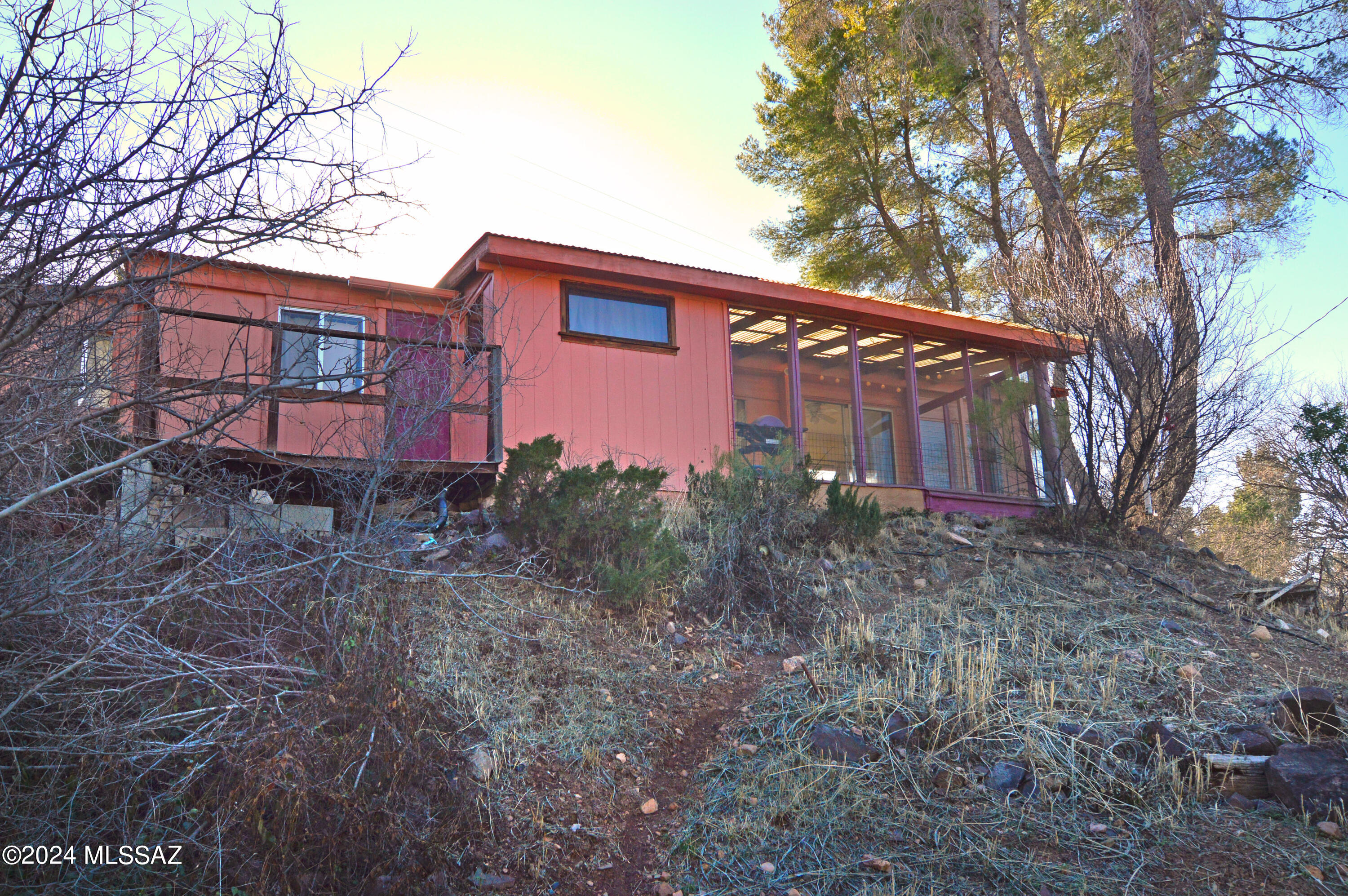 Sweet 490sf 2Be/1Ba vintage mobile c.1959 (Affixed), on 0.81 acre & including a private Well. Nicely maintained & charmingly appointed; many (but not all) furnishings convey, including 2 Induction (Kitchen) Hotplates. Near the Duquesne Ave & Harshaw Rd intersection, you'll be within Town boundaries & a short walk to all Patagonia amenities. The home sits up high near Harshaw Rd. The wooded setting is surprisingly large & private. The property gently dips down to a serene meadow where its driveway takes you to the parking area, wkshop-studio bldgs & vintage barn (w/composting toilet for your camping friends). All the buildings are vintage & may need some attention or updating, to your liking. Lovely views & an excellent community + oversized parcel to add a new home -or maybe even a BIZ!