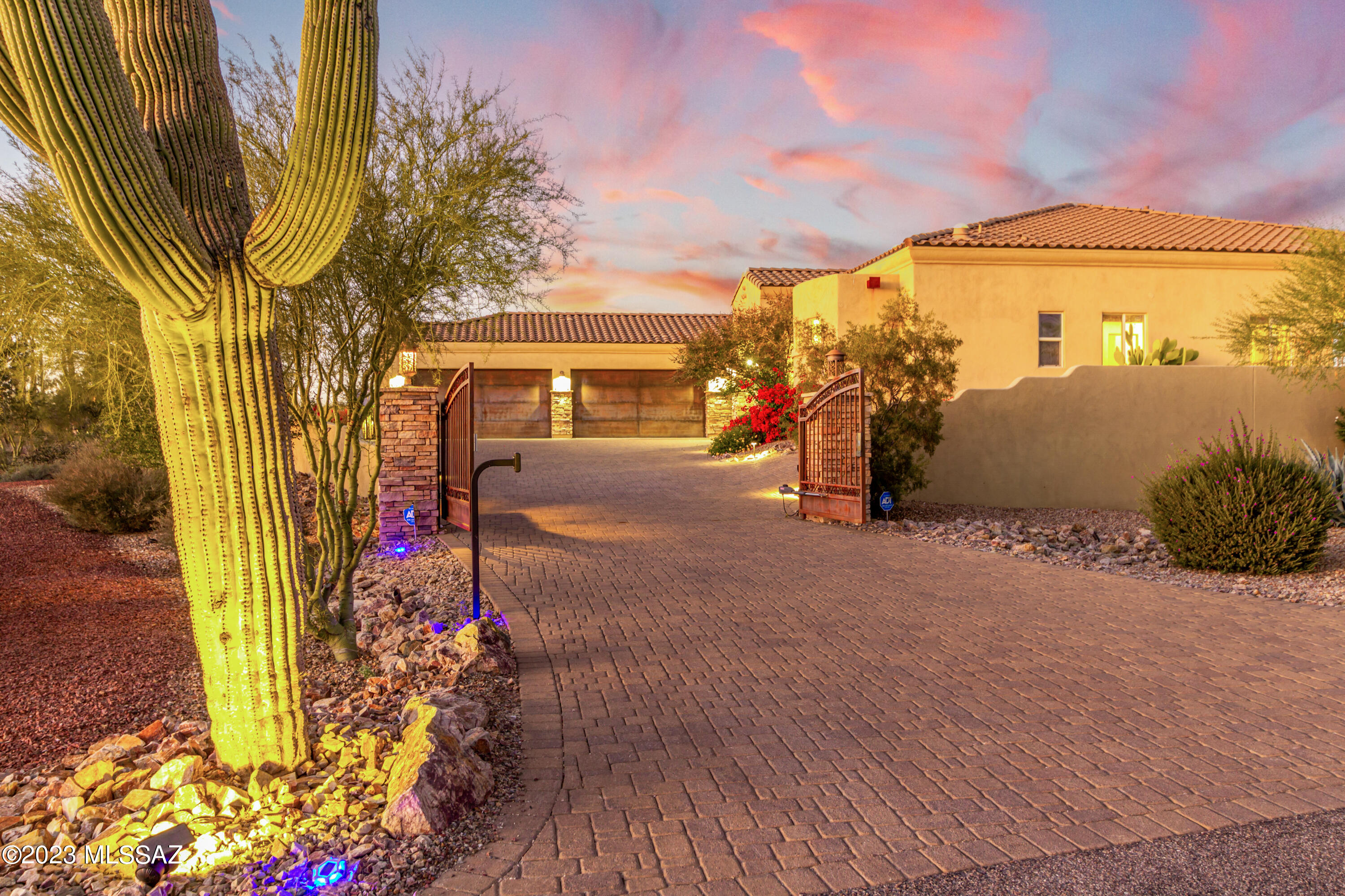 Welcome to this stunning custom estate, a true desert oasis sprawling over a 3.3-acre corner lot! A gated paver driveway, 4-car garage, and a gorgeous mature landscape are just the beginning. Fabulous interior showcases attention to detail throughout! The circular foyer leads you to the formal dining room and an inviting great room  with a fireplace niche. Natural light filled the spaces, complemented by a neutral palette, solid wood 8-ft doors, chic light fixtures, plantation shutters, and tasteful  travertine flooring, Gourmet kitchen is a cook's delight! High-end SS appliances, a wall oven, stone backsplash, granite slab counters, a pantry, a prep island, ample cabinetry, and a 2-tiered island. Property has finished walking paths and multiple spots to enjoy the landscape. Enter the primary bedroom to find direct access to the back, a walk-in closet, and a lavish ensuite with a jetted tub & two vanities. Adding to the home's functionality, you have a versatile den, a bonus room, and a secondary bedroom with its own bathroom. Laundry room includes a sink and cabinetry for your convenience. But the real magic happens outside! The east-facing backyard is a PARADISE, featuring a covered patio, synthetic lawn, built-in BBQ, well-laid pavers, a fire pit, and dog run w/storage shed. The RESORT-STYLE heated pool & spa are the crown jewels, promising year-round enjoyment. PLUS! Follow the pathway to your gazebo, perfectly positioned to embrace the unparalleled mountain & desert views and captivating sunsets & sunrises. You'll LOVE this property!