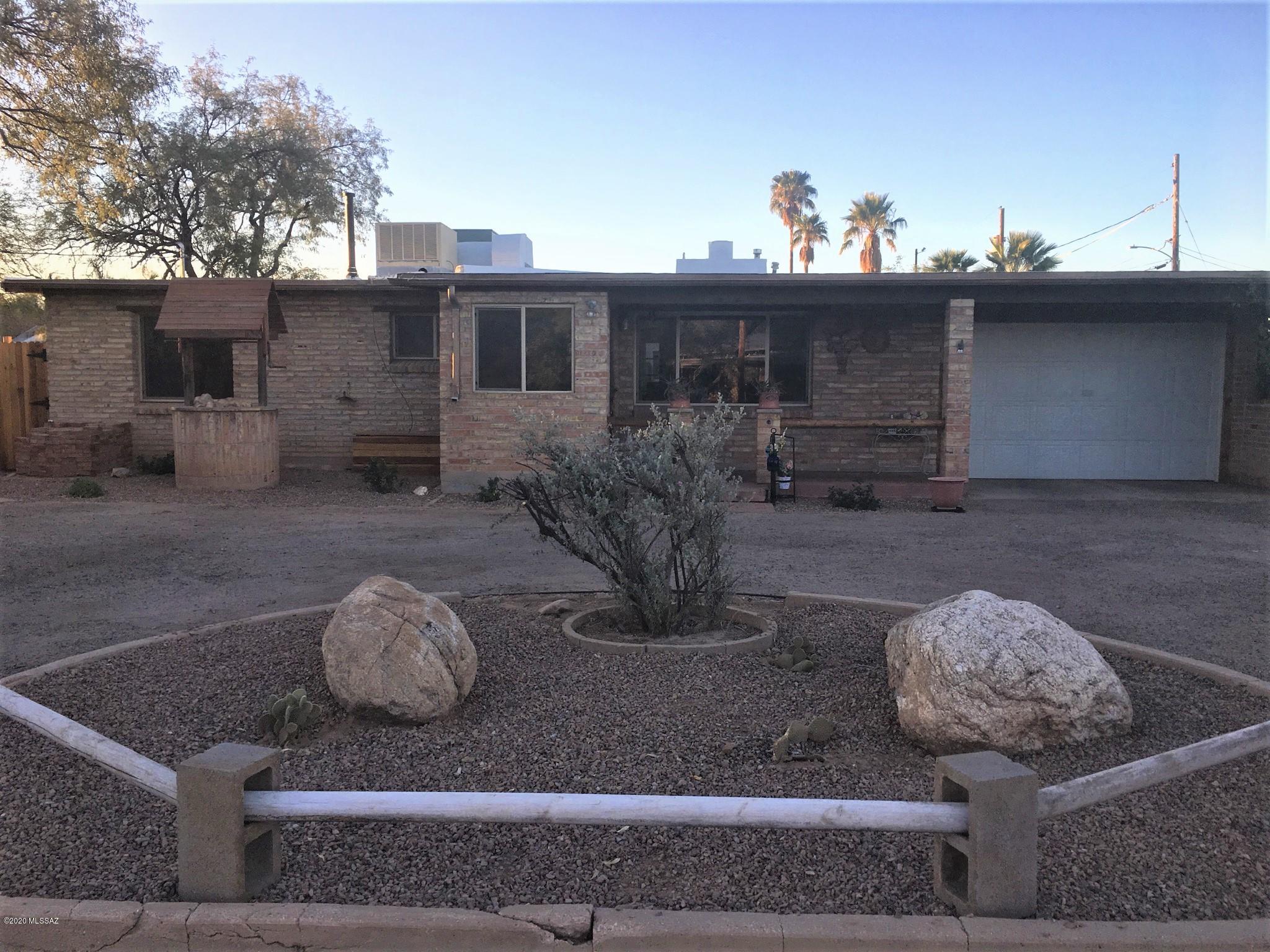 Come and see this fascinating ''One of a kind - Cabin in the Desert'' situated on a corner lot with ample space for an RV or Semi-Trailer-truck. Old world western charm! Owner states that most of the wood ceilings, paneling and beams originated from Mount Lemmon! Quality double red brick construction with brick flooring, A/C & Evap, Dual pane windows, 200 Amp electrical service, Stainless Steel appliances and Travertine counter tops, 2 Water heaters, Laminate flooring with stone/porcelain flooring in the bathrooms, stunning rock fireplace, laundry room with a supersized single garage. The rear yard is fabulous for entertaining! There is a covered Ramada with a BBQ grill that's perfect to entertain your family and friends. Or, this home could be perfect for a ''Bed & Breakfast'' business!