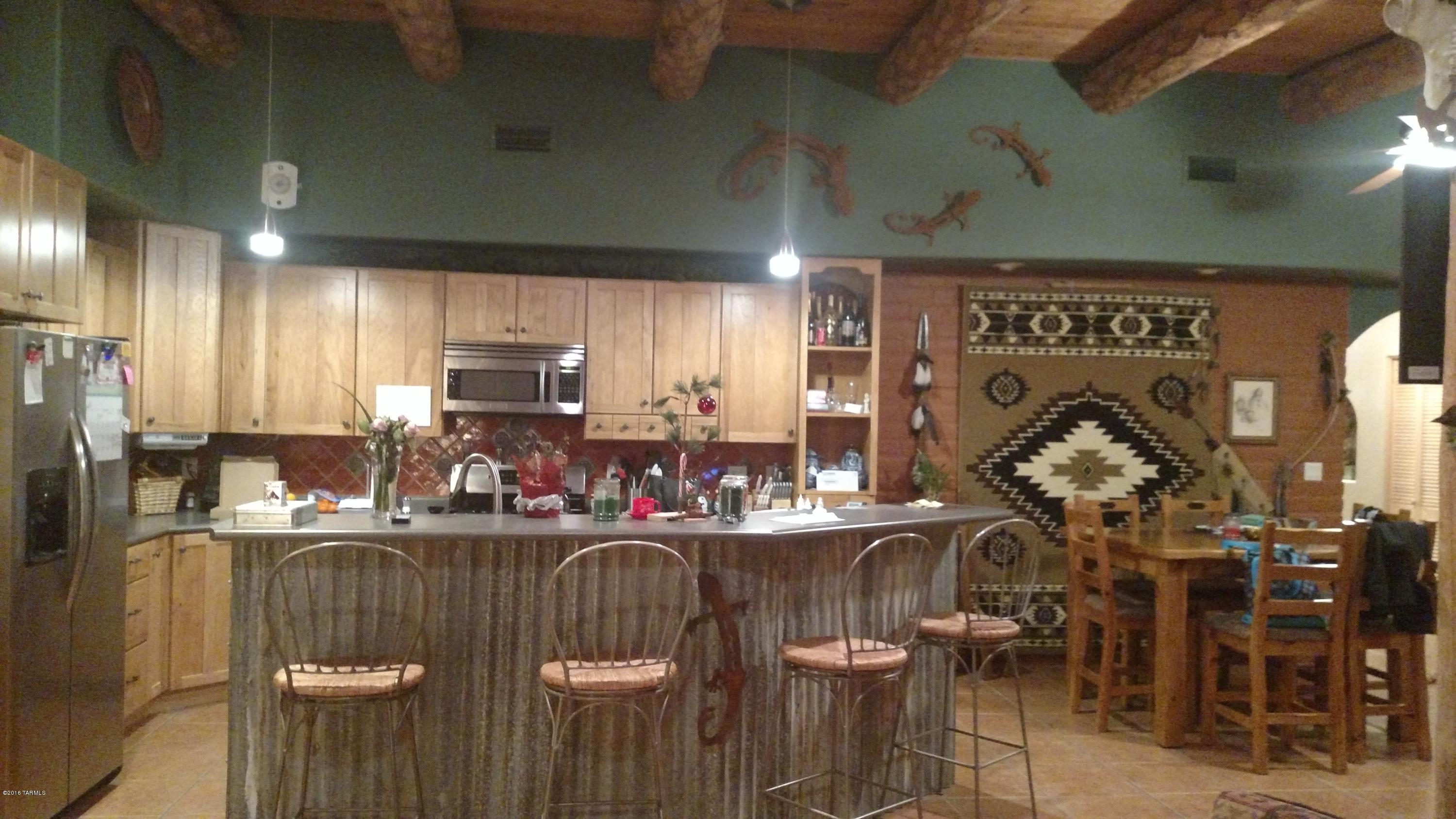 Hand-hewn wood beams are the focal point for this wonderful adobe home on over 4 acres of horse property! 3 bedrooms plus den/office. In addition to the wood beams, the kitchen has stainless steel appliances, hickory cabinets, and loads of storage. The covered patio at poolside has misters and a sound system. A fire pit, ramada, fountain, and mountain views make this an entertaining paradise! Low maintenance yard with artificial turf, and pool service is included in the rent!