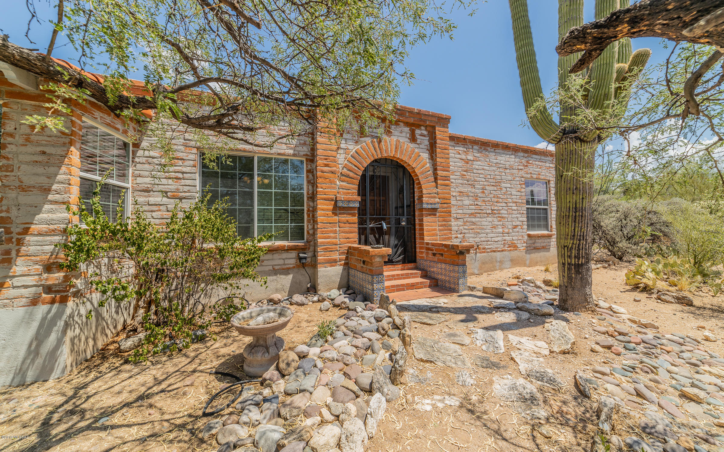 This rare find in northeast Tucson in the shadow of the Catalina mountains is on the market!  Burnt adobe one-owner classic territorial home on 3.9 acres with no deed restrictions!  Main house features an oh-so comfortable great room w/ stone-faced fireplace.  Kitchen w/ breakfast nook.  Formal dining room.  Full wall of windows in great rm w/ serene views of expansive brick-paved patio.  3 spacious brms include master suite which opens to space for cozy den, home office, or library.  Master bath features double sinks, large walk-in shower.  Free-standing guest house w/ delightful living rm, kitchen w/ breakfast nook, one brm, 3/4 bath, covered front patio & attached carport w/ laundry/storage.  All tucked away on a private lot w/ plenty of room for pool/horse facilities/additional garage