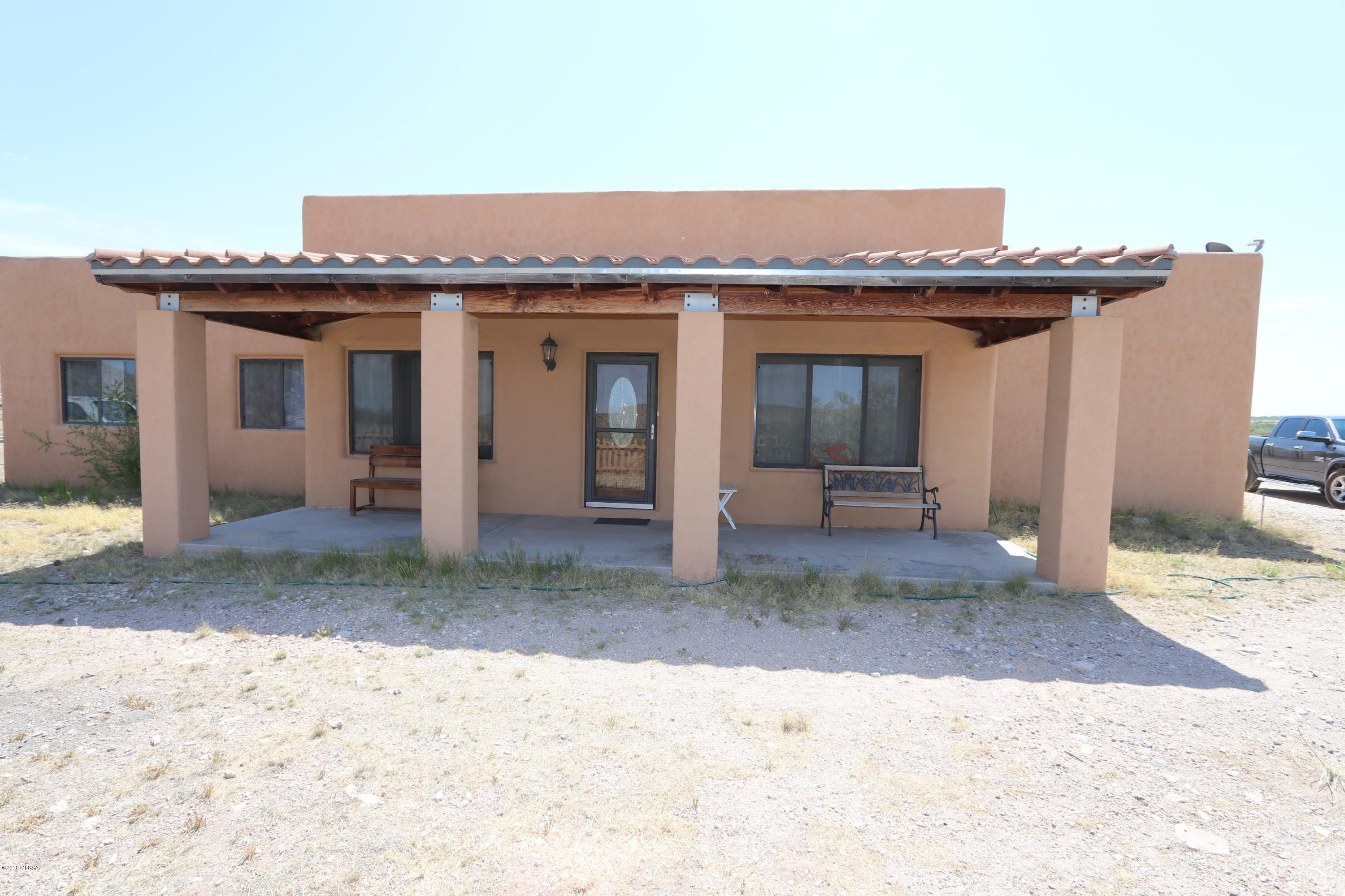 Santa Fe style house on five acres outside Benson, AZ. This property is Located just 25 minutes east of Tucson. Main house has 3 bedrooms 2 baths. There are facilities for animals and a workshop. Open floor plan is ideal for a family.  Nearby you will find the historic town of Bisbee and the infamous town of Tombstone. Karchner  underground caverns (one of the most visited attractions in AZ) is 15 minutes away. Benson has shopping, restaurants, health facilities,  great schools,  a public golf course and an airport. The property has a  personal property manufactured home that is rented  out, exterior walls are stucco, interior has an eat in kitchen living room, one bedroom and one bathroom; ideal for guests, family members or extra income.