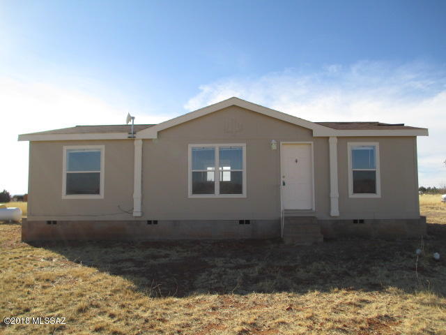 Something special awaits you at the end of this road. This three bedroom two bathroom 2007 manufactured home on 4.25 acres is literally at the end of the road. Split floor plan, eat-in kitchen, laundry room, fully fenced. Adjoining public land, this home is perfect for anyone wanting peace and quiet. It would be the perfect place for your family, whether that includes kids, pets, horses, or all of the above! The home has been extensively remodeled. What's new? Paint inside and out, upgraded plank flooring, refrigerator, washer and dryer. Enjoy unobstructed views of the nearby Whetstone Mountains. Add a garage or barn on the existing large concrete outbuilding pad. Owner may finance qualified buyers.