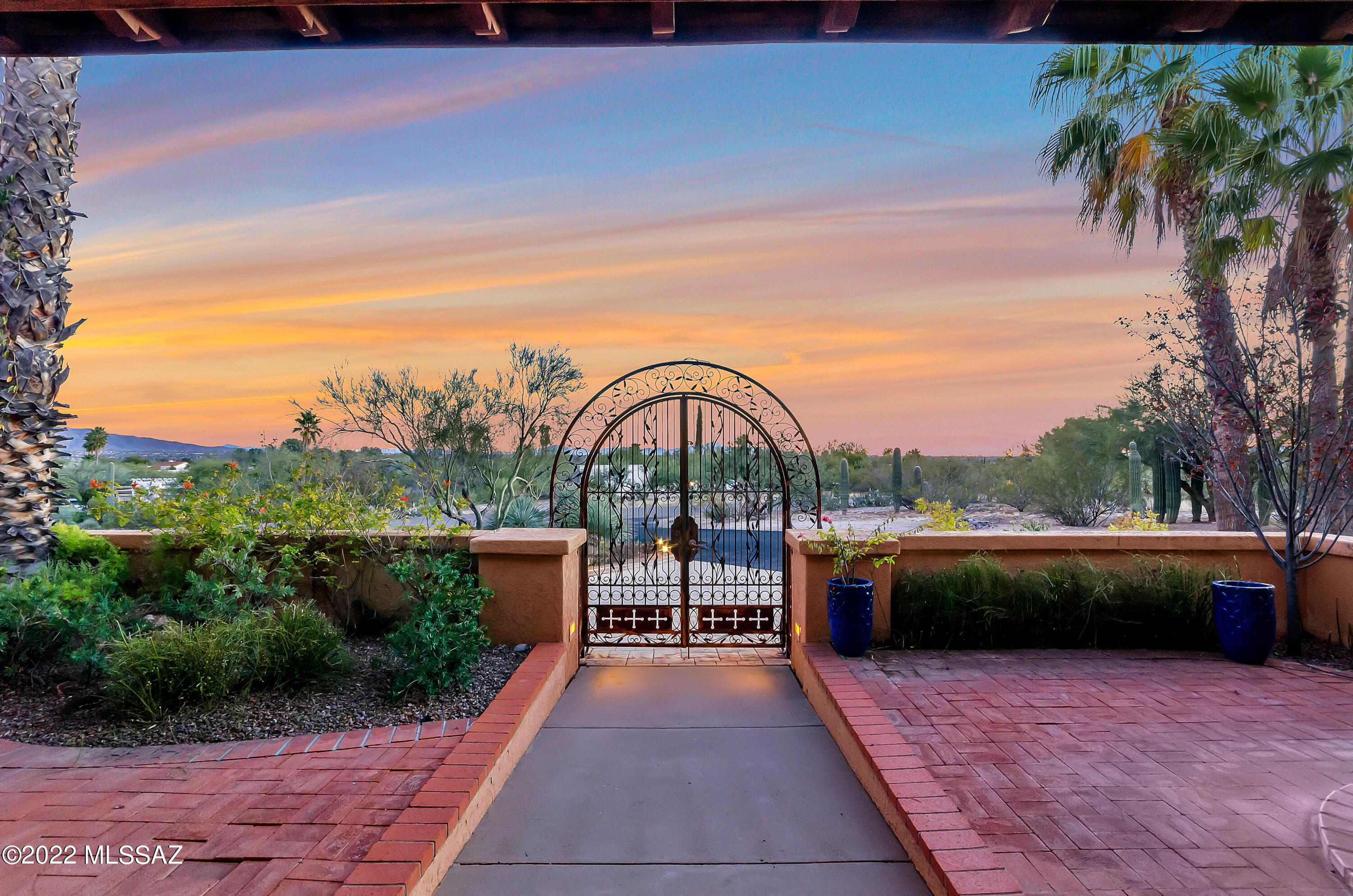 This stately property sits on 1.6 acres promising a warm welcome to all who enter. Walled courtyard & fountain greet you. Wall of windows draws your attention to the manicured lawn w/beautiful pool/spa! Sweeping mountain views of the Catalina's & Rincon's. Custom iron work, deep cov'd patio & fp make for outdoor entertaining. Timeless wood floors, cathedral ceilings, french doors & solid built-ins. 5 brs + large rec room offers spaces for fun galore! Split plan allows a complete level for master suite. Mstr offers 1 of 3 fp's, luxurious bath & a closet to envy. Stone fp, beam/plank ceiling, Canterra stone columns define the formal din rm/liv rm. Kitchen offers abundant counters & cabinets, granite/corian + 2 sinks. Fam rm/Office or bright breakfast room. Tennis court, 1/2 basketball court