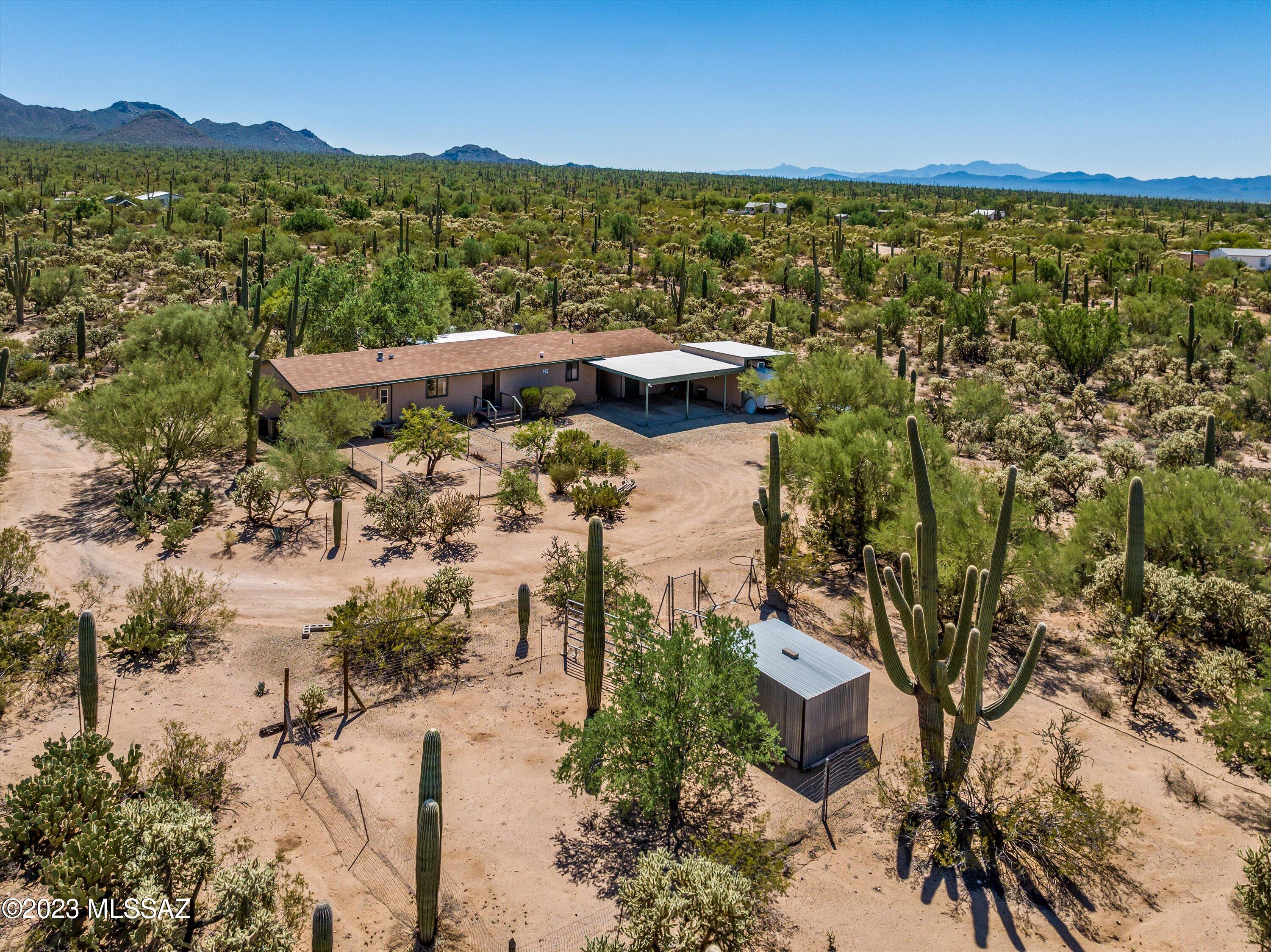 Manufactured home on absolutely gorgeous 5+ acre parcel, just outside of Saguaro National Park West. If you need 360 degree mountain and desert views, you must see this property. Home has not been updated much on the interior, but has been well maintained and scrubbed clean, has beautiful landscaping, a very pretty back porch, perfect for taking in views. Large, permitted separate workshop/storage area with electrical on slab PLUS carport for 2 cars plus a third bay for a camper van or the like. Gated drive and additional chain link fenced areas are perfect for animals. Roof and HVAC recently serviced, septic cert is done, engineers cert for FHA/HUD in hand, tags still visible, Avra Valley Water. HVAC approx. 5 years old.