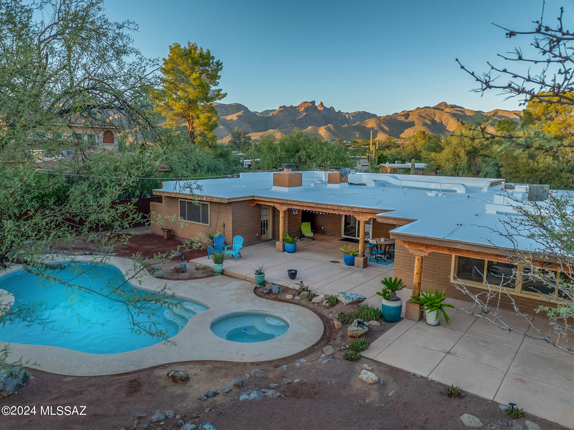 New price improvement AND seller willing to contribute towards closing costs/rate buy-down! Stunning southwest-style resort paradise with sparkling pool, spa, koi pond and gorgeous landscaping abound. Unique setting with mesquite bosque set as the backdrop for your private retreat. Truly a special property, this home features concrete flooring throughout, concrete countertops, SS appliances and custom-wood cabinetry in kitchen, wood columns on interior and exterior, granite countertops in both bathrooms, three cozy fireplaces, dual-paned windows, finished garage w/ storage. Entertainer's dream features huge family room, dining room, access to back patio through all rooms, two west-facing covered patios with integrated LED lights. No HOA. Bear Canyon trail, cycling, restaurants, groceries.