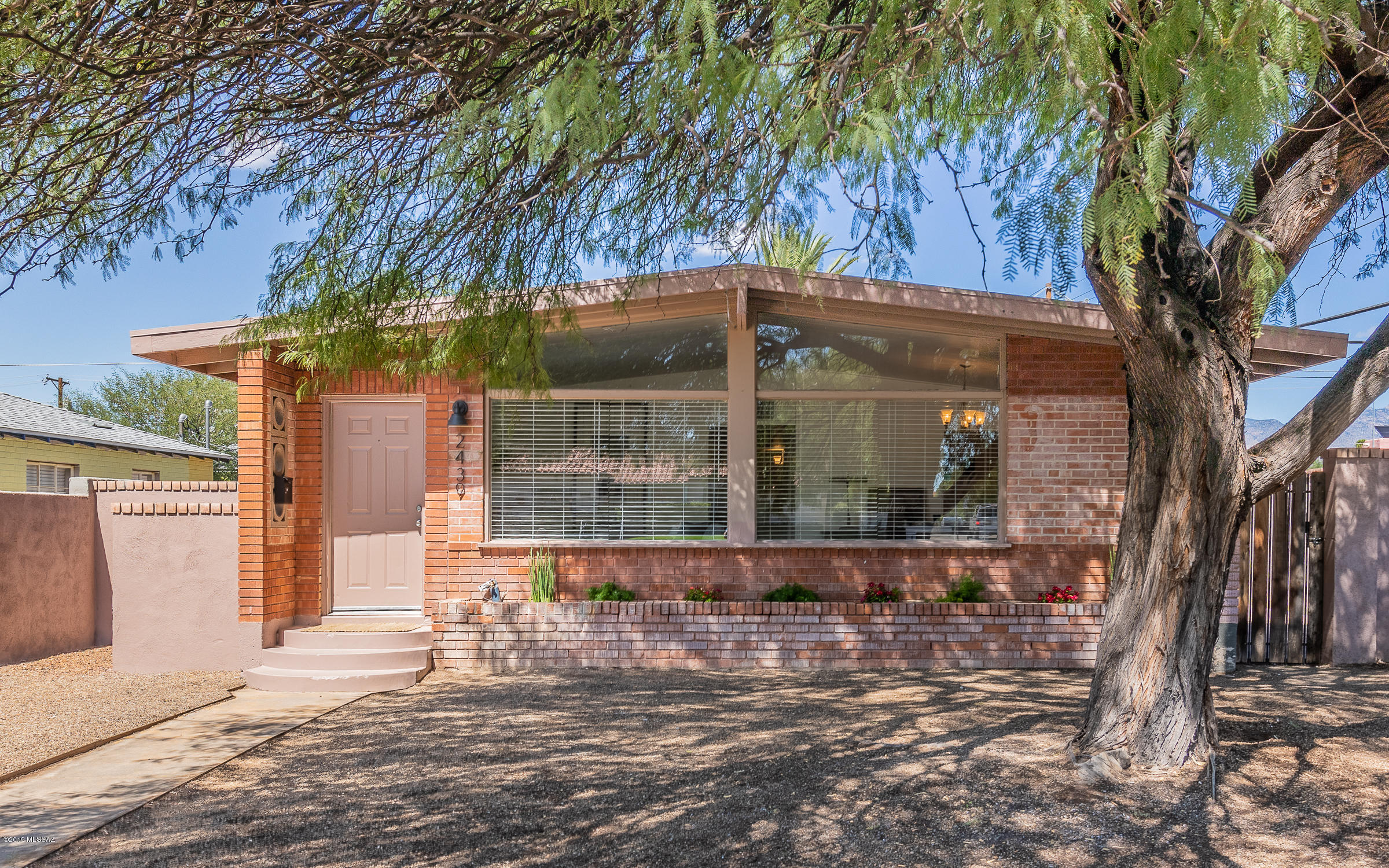 PRICE REDUCED! Come see it in person. Walk right in + experience an entire wall of white stone with a corner, gas fireplace. Vaulted ceilings w/the A-frame windows bring you right back to that 50's charm. Out front you'll find a planter bed w/drip system that will keep whatever you choose to grow lively + thriving. Dining area is bright and airy. Kitchen boasts brand new SS appliances, wall-oven + cooktop with overhead microwave + fingerprint-resistant dishwasher for the little ones. New sink + kitchen faucet w/sprayer. New carpet in all the bedrooms. New vinyl plank flooring throughout. Check out the covered parking spot with garage door+storage space! Fully-walled yard. Steps to Rincon, Tumerico, bike/walk to U of A! Buyer to verify all facts+figs, incl those in MLS.