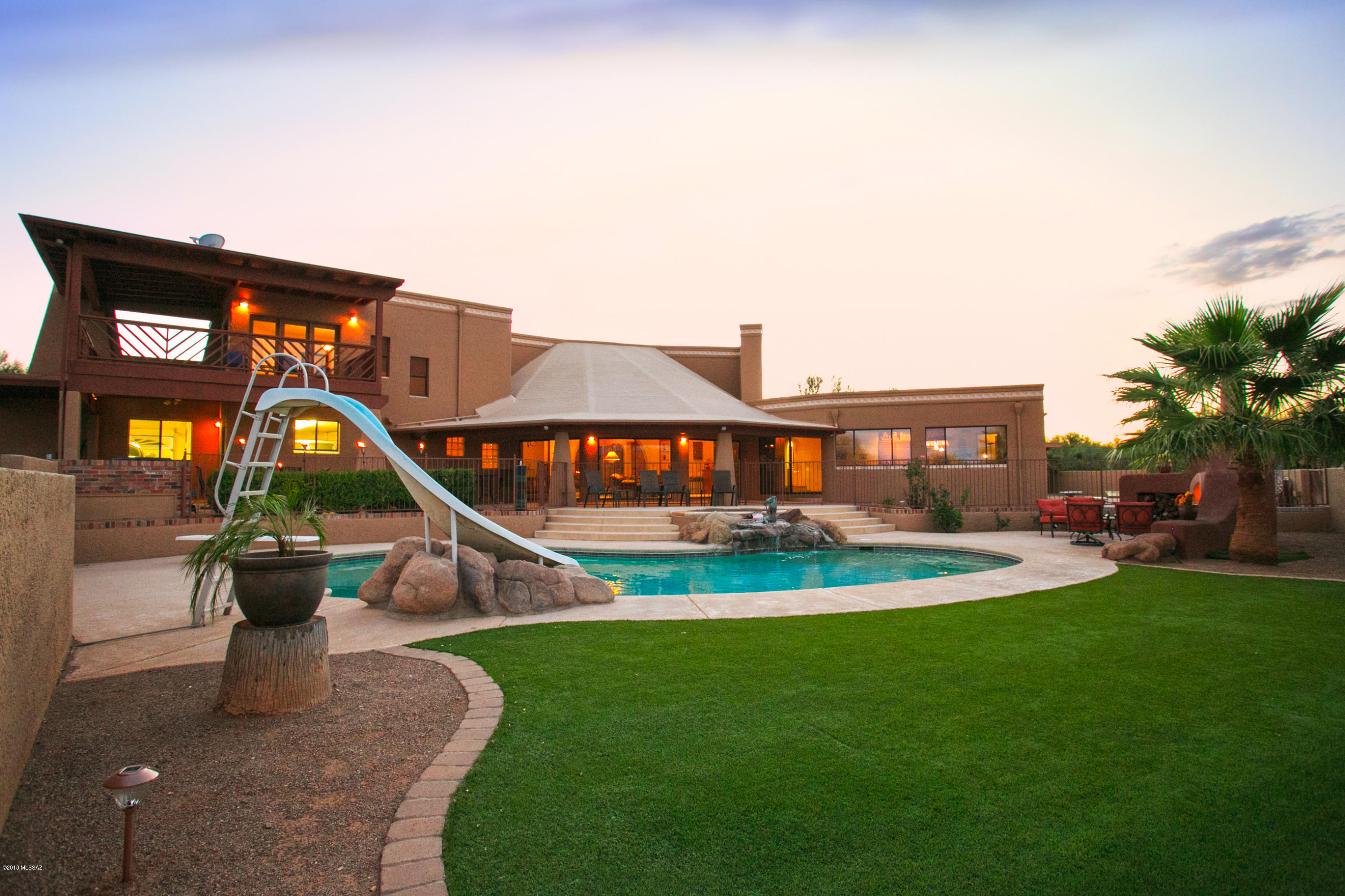 Come home to your own private resort on over an acre! Great backyard with pool, spa,turf,fountains,fireplace and barbecue. Perfect space for outdoor entertaining year round. 3,960 sq ft custom built home with 4 bedrooms and 3 1/2 baths. Master suite has sitting area, fireplace and it's own porch with views galore. Kitchen has plenty of cabinets, pantry closet, trash compactor, ice maker and B/I refrigerator. Separate freezer in adjacent laundry room. Family room with B/I entertainment center is large enough to accommodate all your gaming passions. 2 stall attached garage and separate 3 stall garage. Worship building has exercise room with a bathroom, sauna and HVAC unit. Lg room in shop can be easily converted to casita. One of owners is a licensed RE Broker in the State of Arizona