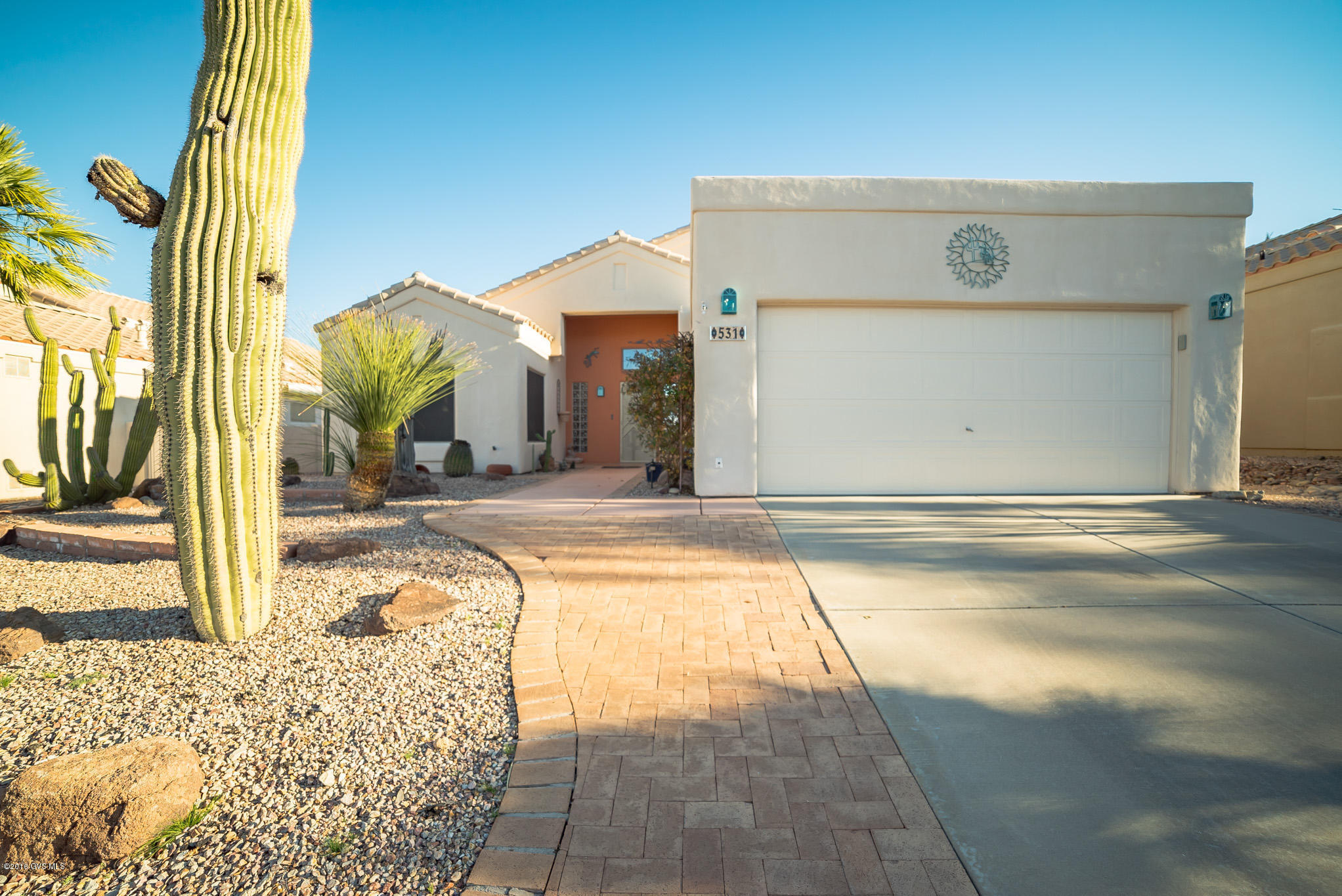 A terra cotta accent colored entry leads you into a great room with vaulted ceilings and a wall of sliding glass doors and transom windows filling this home with natural sunlight. Southwest colors and a center stage two sided fireplace make it very warm and comfortable. The radiant kitchen has a functional U shaped kitchen, tile backsplash and countertops plus a serving bar with custom lighting fixtures. The corner dining area also offers easy access to a fully screened Arizona room where you can relax and enjoy cool breezes. The master bedroom has wood flooring and the bay window alcove creates intrigue with interesting ceiling lines. Step out onto the tiled back patio where brick pavers create a party deck featuring a centerpiece cactus and palm garden, a built-in grill with side  burner and a dining deck where you can enjoy a meal while taking in the beautiful mountain views. It even gets better - this home can be purchased totally furnished!