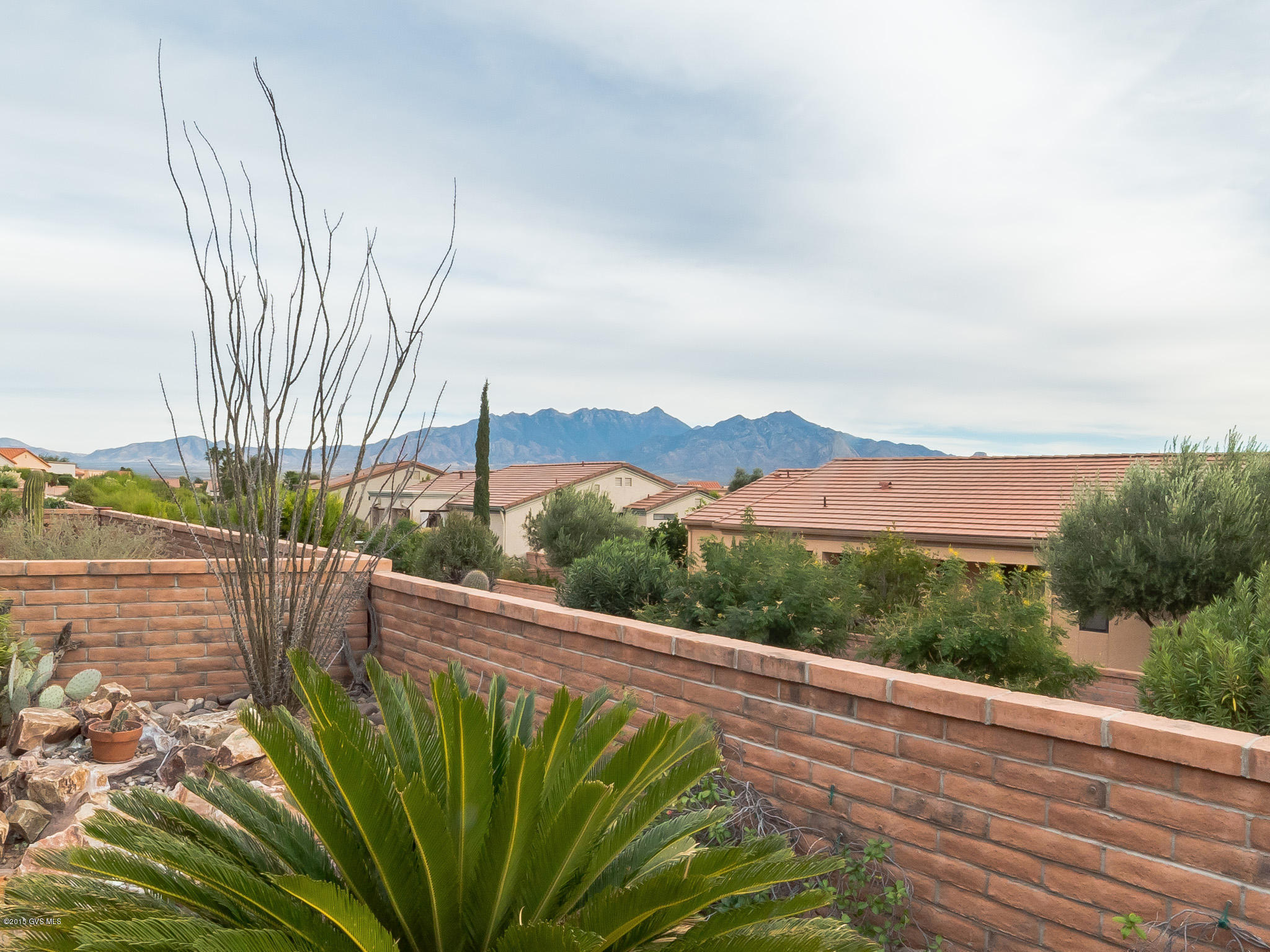 Welcome to this lovely updated Verbena floorplan with all new tile floors and custom interior painting located in San Ignacio Vistas II. Stroll through the front courtyard and notice the trees adorning the walkway. Enter through the door and you will immediately notice the interesting curved walls, 10' ceilings and the natural sunlight through large windows that are perfectly placed. The kitchen has rich cabinetry and a breakfast bar as well as a sunny breakfast nook where you can enjoy your morning coffee and light meals while enjoying views of the Santa Rita Mountains. Double French doors will lead you to the den where you can have your office, exercise equipment or overstuffed chair to read your favorite book. Retreat to your master bedroom suite with its corner view window and  modern curved wall design. The master bath has an expansive counter top with dual sinks, a separate shower and corner tub. You will love spending time on your wrap around patio with red brick pavers enjoying both sunrise and sunsets over the mountains!