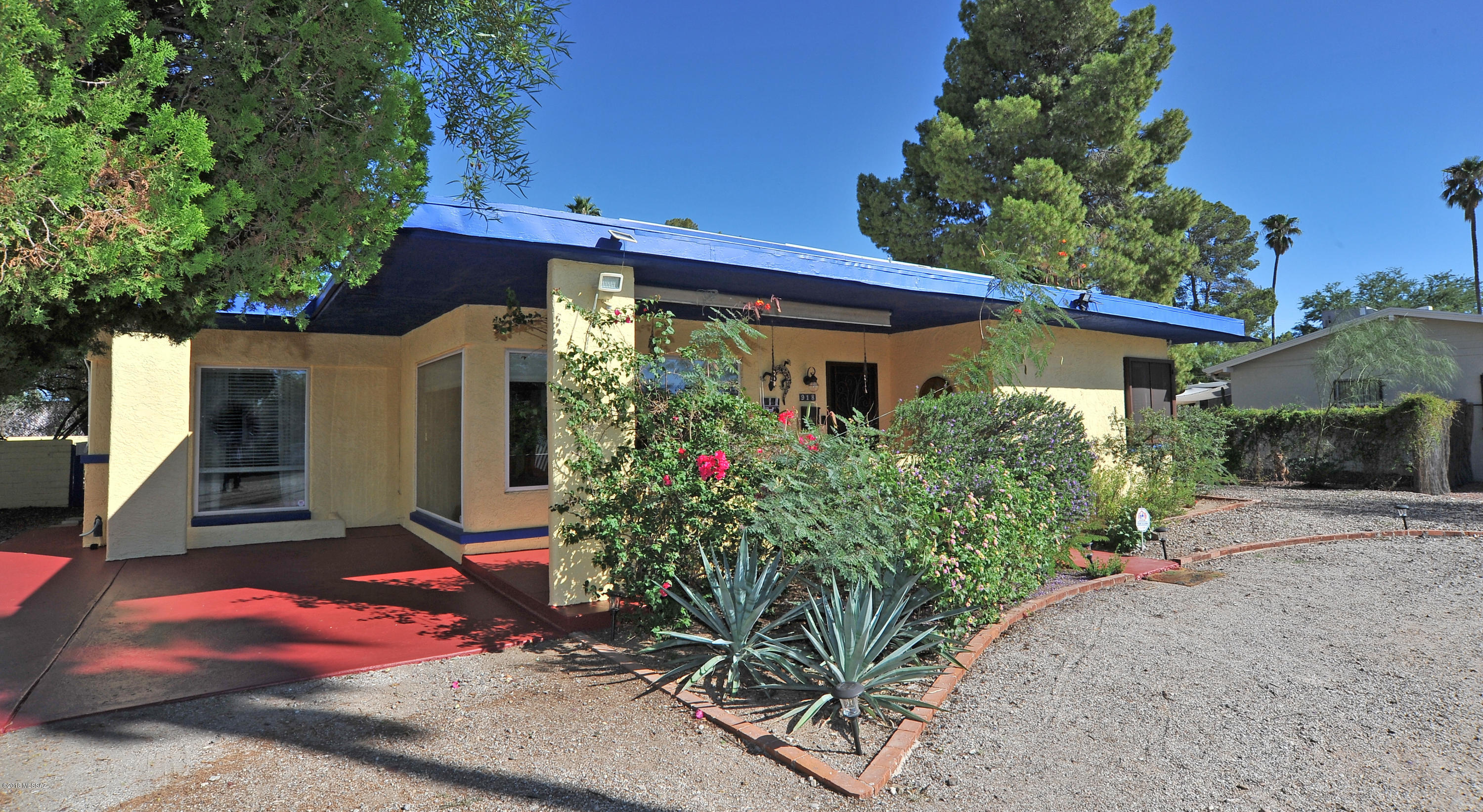 Sam Hughes adjacent, enjoy all the benefits of this great location including Hughes Elementary School without the high prices. Grand size living room (17'x22') & Den (20'x20') surrounded by windows and French doors make for light, bright spacious living. Updated with Rojo's tinted concrete and travertine floors, dual pane windows, security screens and doors, honeycomb blinds, new paint inside and out, new dishwasher, range, ceiling fans, water heater, and 40 amp service for RV or shop. Fruit Trees, water feature, lush backyard with 32'x19' flagstone patio, shade sails, great for entertaining, gardening or just relaxing. Take the 3rd St. bike path to U of A, groceries and other assorted shopping and services just blocks away. Great value!