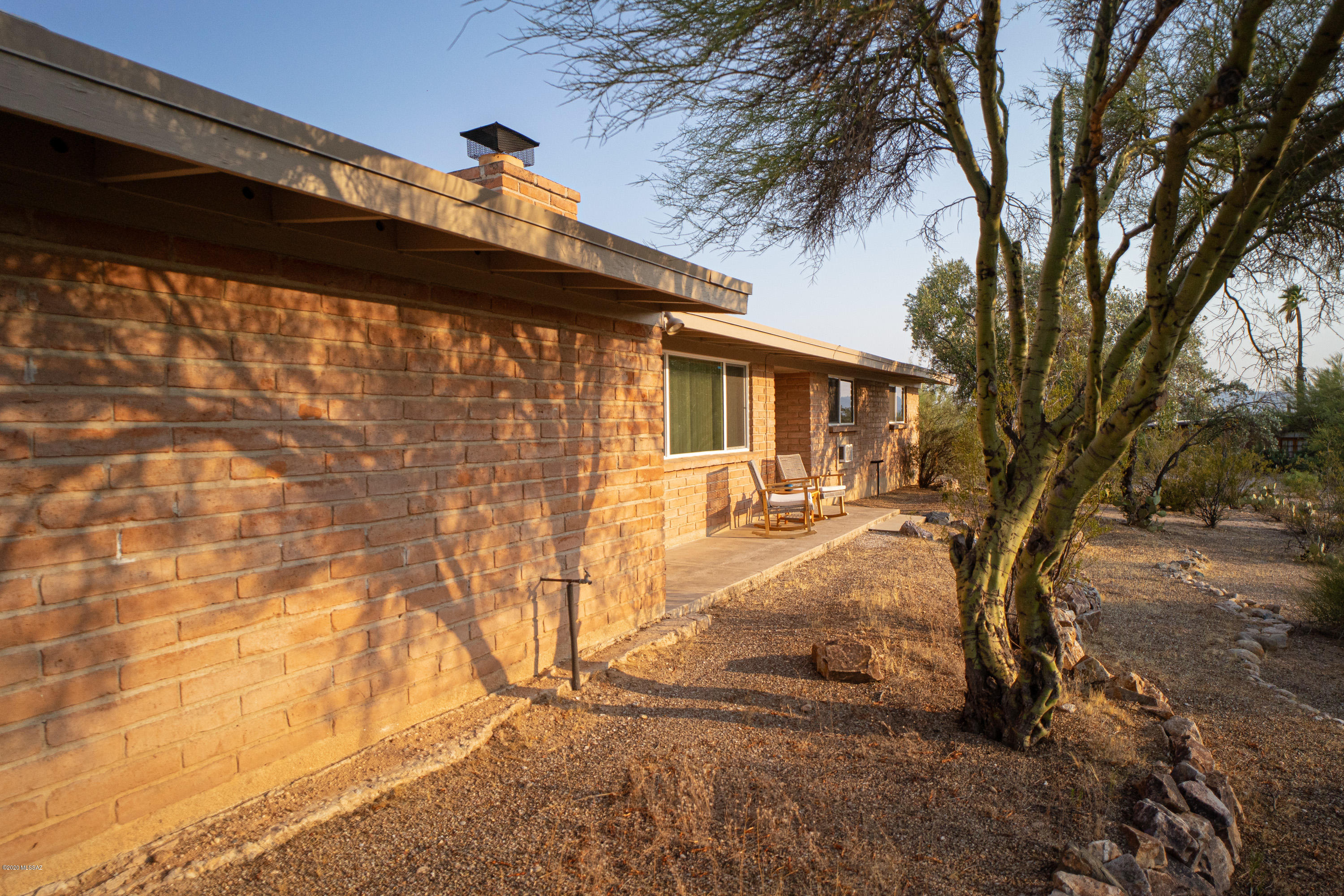 Watch a beautiful sunset every night - natural desert landscape with mountain views, this updated and well kept 3 bedroom / 2 bath Midcentury Modern Burnt Adobe Ranch sits on .83 acres. Bright & open kitchen and dining area, plus living room with fireplace. Ceramic tile flooring throughout. Low E dual pane windows added in 2019. Covered patios on the east and west. Two car attached carport with storage & laundry shed. Roof was recoated in Sept 2019.