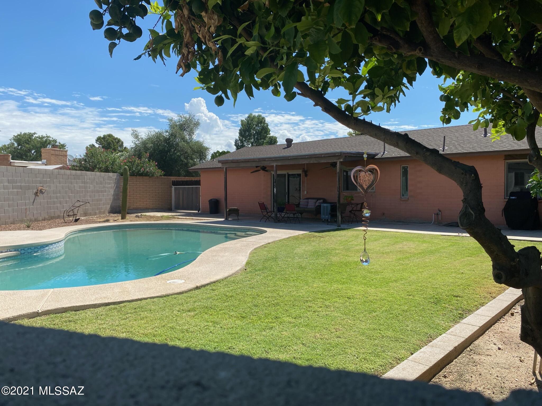NO HOA. Beautifully updated and well cared for 3 Bedroom 2 bath home.  16X16 diagonal tile through  out.. Kitchen has top of line whirlpool Stove with 2 separate ovens, pull out pantry cabinets and recessed lighting, Breakfast bar seating,Opens up to  great room with separate living room Good size bedrooms w/ plenty of storage space. Newer energy efficient windows and doors. Nicely flowing floor plan graciously moves from one room to the next. 2 car garage (has access to the attic for additional storage), New Roof in 2017, has A/C and the greatest back yard with extended covered patio for family and friends to enjoy. Pebble tec pool with an island for sun lovers .Grassy area with fruit trees on sprinkler system.. Separate yard has a  workshop  with electric. Location, Location, Location!!!