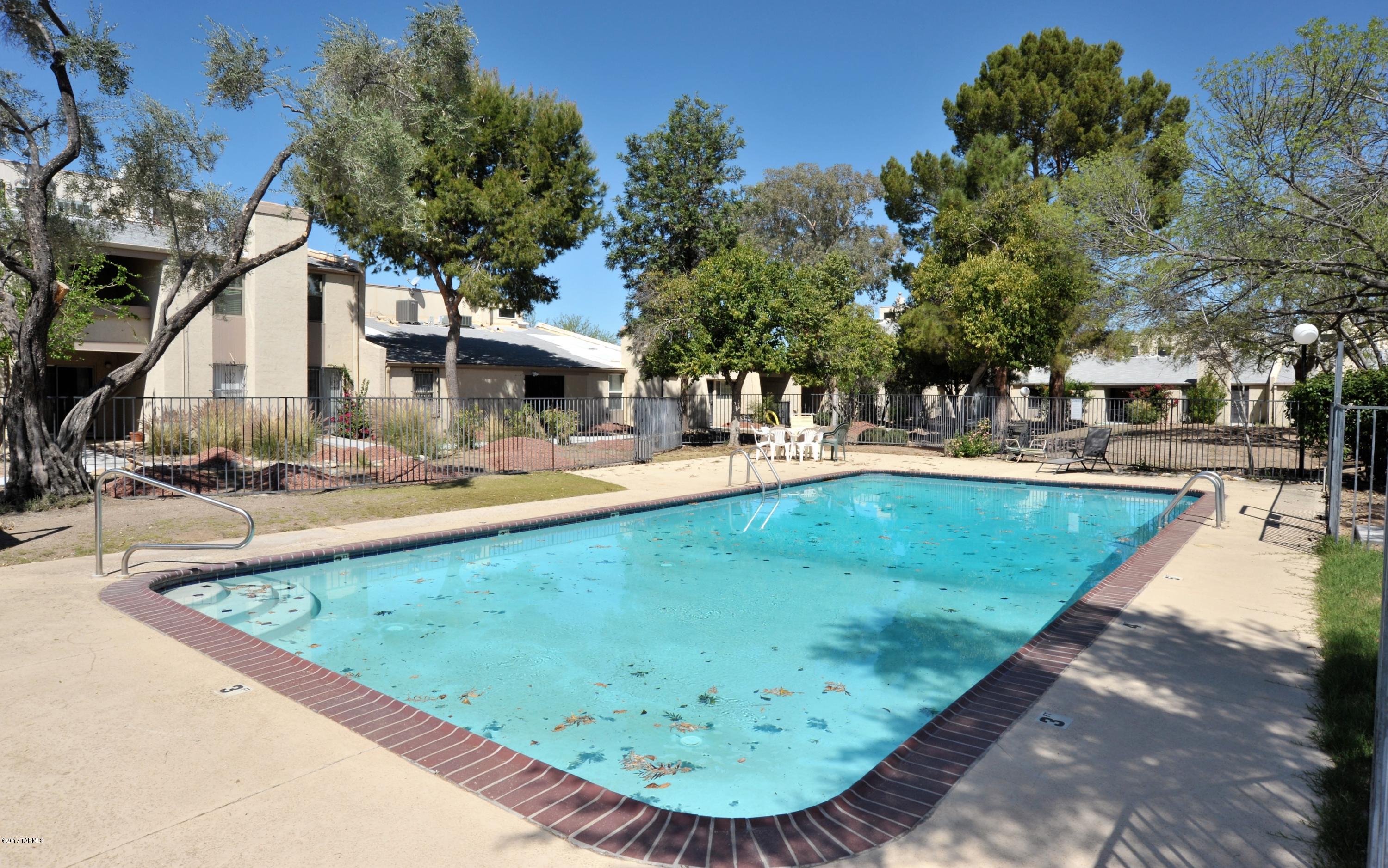 Updated & move in ready, 1,236 SqFt two bed/two bath+Den townhouse style condo in desirable Central Tucson. Convenient location for U of A/Banner Medical students/staff, walk to Racquet & Fitness Club & River walk. Maintained grounds include walking paths & refreshing pool. HOA includes water, pool, termite, roof, hazard insurance, exterior maintenance & rentals allowed. Home has a split plan w/second bed+bath upstairs, ideal for student/roommates or downsized low maintenance living. High ceiling in the living room with fireplace & view of the grounds/pool with no neighbors above. Brand new HVAC (2016), recent water heater, all appliances convey (washer & dryer in unit), recent carpet flooring. Come see for yourself today, not a lot of move in ready inventory available in this price range.