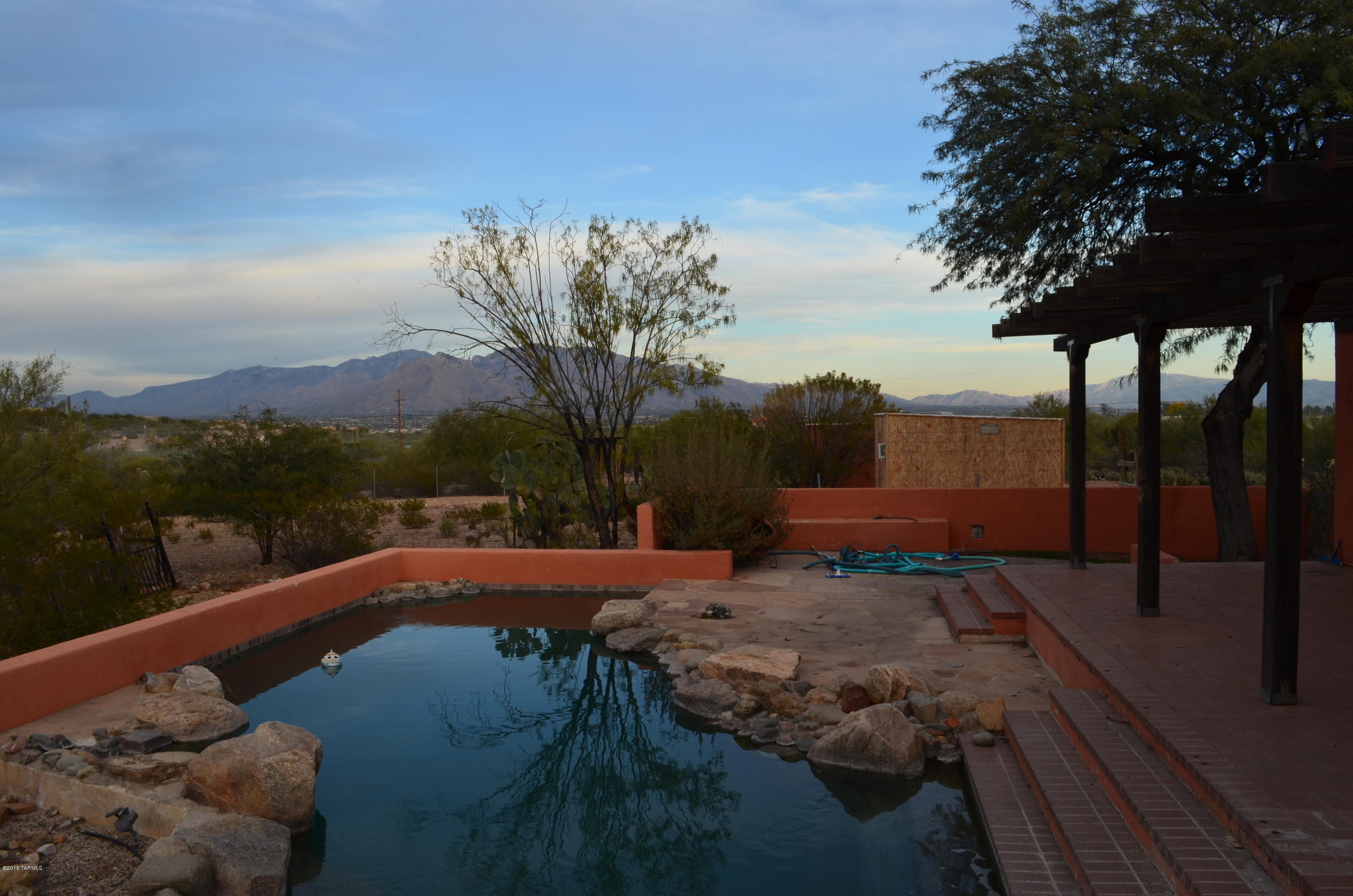 Feels like 20 acres.  A lot of thought went into the location and design of the home. Views are maximized and neighbors not visible from most view points.  Hard to believe you are only 15 minutes from downtown and even closer to I-10 and lots of shopping choices. Inside large rooms with classic viga beams, kitchen with stainless appliances.  My favorite room is the over-sized great room/dining area.  French doors look out over the Catalinas and there is a fireplace. Large bonus living room off the garage. Both the living room and great room have plantation shutters.  Dual pane windows throughout the home.  Outside there are covered patios surrounded by an undisturbed desert.  Off the back patio is a pebble tec pool and spa. Exterior doors in ALL the bedrooms. 2 rooms have direct access to pool.  Masonary/stucco exterior walls with Phoenix brick flooring throughout the home makes it economical to heat and cool.  Underground propane tank to heat pool.
