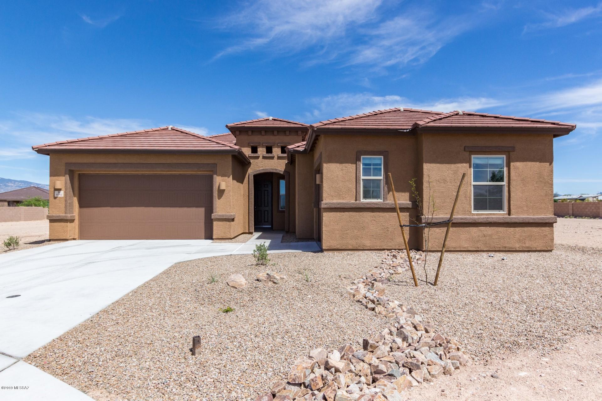 Stunning home with mountain views.  This home boasts beautiful tile, a neutral palette and the perfect kitchen.  Cozy up to this fireplace and feel the ambiance of a cool Tucson evening! This kitchen hosts dark rich cabinetry, stainless steel appliances and a beautiful custom backsplash. A breakfast bar, dining area and formal dining area provide ample space for entertaining!  Lovely granite and a pantry add the finishing touch!  The master suite is generously sized and is complete with an ensuite of double sinks, granite countertops and an oversized walk-in shower.  Step outside onto this covered patio and take in these gorgeous mountain views!  This large lot is just waiting for your personal touch! Create your own oasis in the desert! Dont delay - see this one today!