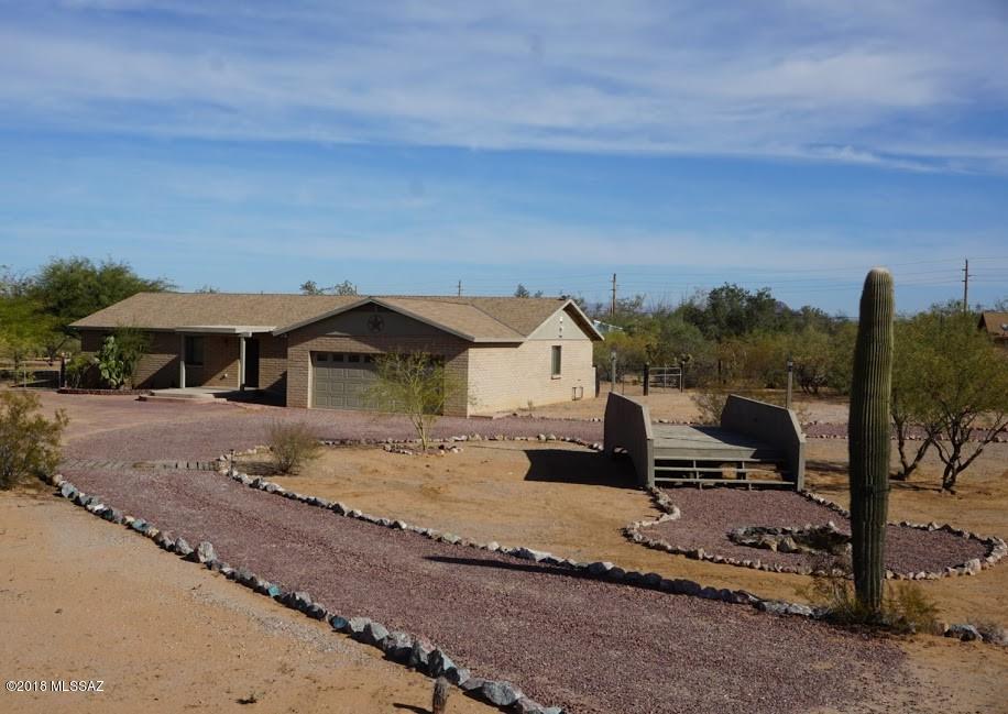 Seller will counter or accept offers between $215,000.00-220,000.00.This 4 Bedroom, 3 Bathroom home built in 2007 on over an acre is located just on the outskirts of the Saguaro National Park and walking distance to Marana Schools. Appreciate 360 degree Mountain View's from you own personal bridge which also makes for a relaxing evening bonfire with perfect star gazing every night. The inside of the home features two generous master bedrooms, an open split bedroom floor plan with skylights, Alarm, AC, title floors and ceiling fans throughout. There is an Oversized Garage, Large fenced yard with a covered patio and plenty of land for animals, your family and privacy. With its perfect location you have access to trails for horseback riding or other outdoor activities.