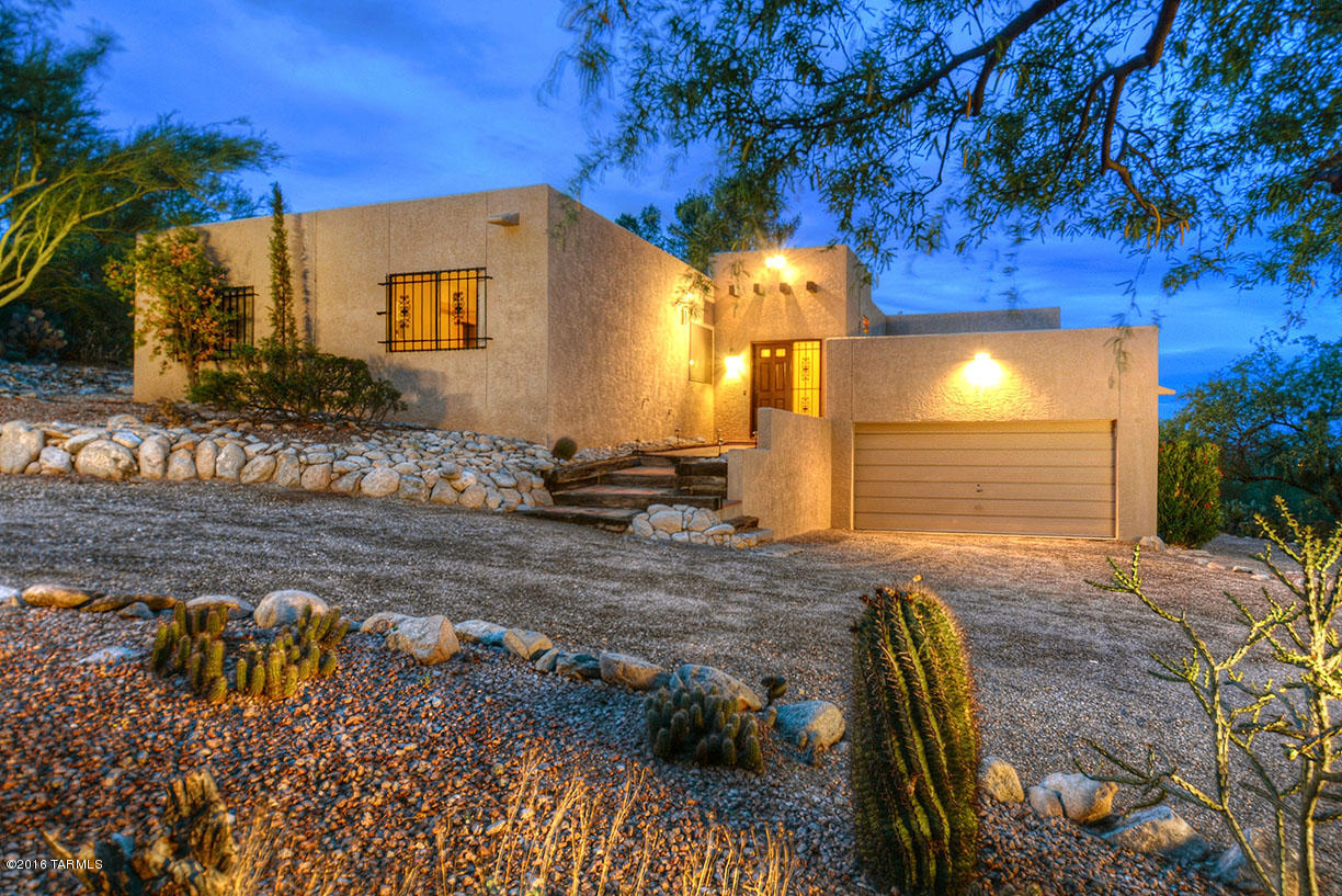 Enjoy incredible mountain and city lights view from this lovely foothills home! A double-sided gas fireplace sets an inviting mood and is surrounded with oak hardwood floors in the living room, family room dining room and hall to the bedrooms. Walk through your French doors onto the covered patio or sun yourself on the brick patio. The updated bathrooms have gorgeous granite counters and feature tile floors and updated lighting. The kitchen is bright and offers both a breakfast-bar and eat-in area with a sliding door out to your deck that has beautiful mountain and city views. Unique storage/bonus room with laundry sink and cabinet off the garage might be a great spot for your wine cellar or man cave. 2 car garage with built-in storage.