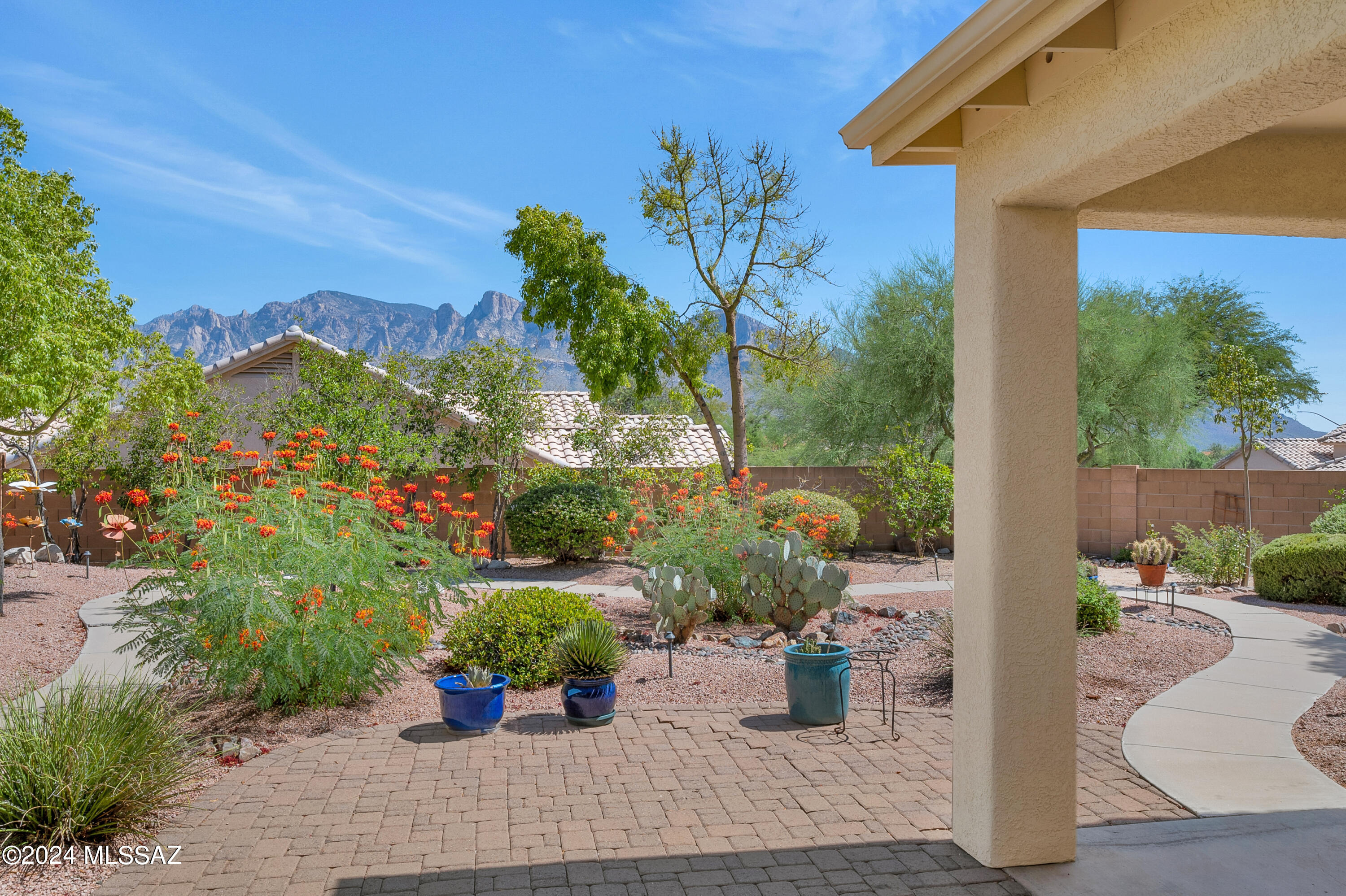 This is the ONE! Gorgeous mountain views abound from the great room, kitchen, and deep shaded porch of this 2559sqft, 4bd/2ba Rancho Vistoso home conveniently located on a corner lot. The coveted split bedroom layout with vaulted ceilings, beautifully remodeled bathrooms, and generously sized rooms welcomes you at every turn. Enjoy the delightful desert garden as you stroll along a winding concrete path in the east-facing backyard, an oasis of peace and beauty. 4th bedroom with double door entrance could easily be an office/den, 3 yr old HVAC and water heater, oversized 3-car garage w/storage. With numerous private parks, a meandering walking/biking path, and easy access to grocery/medical/theater/shops, this community, just stone's throw from the heart of Oro Valley, is truly a dream.