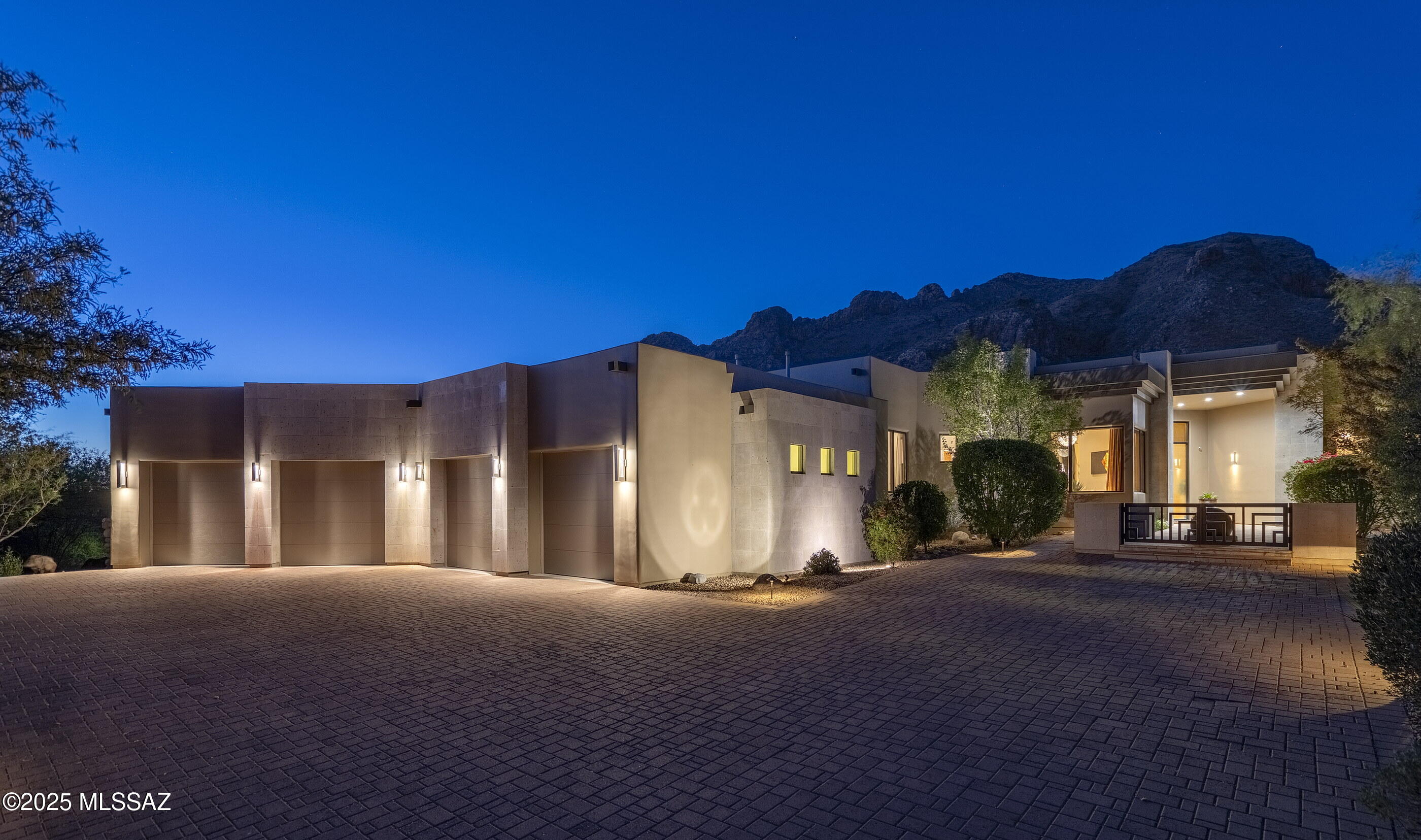 Located within the prestigious Pima Canyon Estates and behind the secondary gates of Sunset Gardens, this incomparable residence blends timeless charm with modern luxury and an unmatched attention to detail. Architectural forms are defined by stucco volumes, accentuated by Cantera stone cladding that anchors the home to its natural surroundings. The arrival sequence leads into a generous motor court, where the scale and proportion of the four-bay oversized garage, complemented by guest parking, defines the space, creating an approach that prioritizes form and function. A sculptural water feature, elegantly placed at the courtyard's entrance, welcomes its visitors to a sense of tranquility, setting the tone for the seamless transition from exterior to interior. Upon entry, a soaring foyer introduces the home with drama and restraint, grounded by elegant limestone flooring that flows throughout the main living areas. North/South orientation invites soft natural light through expansive glass façades, framing unobstructed views of the Catalina Mountains and Pima Canyon, creating a cinematic experience. Overhead, coffered ceilings add architectural depth and understated luxury, enhancing the home's timeless appeal. The spacious formal living area combines both refined entertaining with everyday living, anchored by a striking fireplace clad in hand-carved Cantera stone. Flanking the fireplace, custom built-in millwork offers integrated storage and open shelving, while creating a warm, inviting focal point.

Transitioning beyond the formal spaces, the informal living areas effortlessly integrate with the kitchen, fostering a harmonious open-concept environment. The kitchen, curated as both a visual centerpiece and a high-performance workspace, features natural stone counters, custom millwork, and an integrated suite of Viking appliances, offering a seamless fusion of design and function. A built-in media center and storage cabinets provide both utility and design continuity, complemented by additional Cantera accent cladding that echoes the home's refined material palette. The primary suite, occupying the eastern wing, is a sanctuary of quiet luxury, fitted with bespoke cabinetry, soft natural finishes, and an architectural clarity that supports a sense of retreat. Four additional ensuite bedrooms, a dedicated den/office space, and a guest powder room are thoughtfully distributed for flow and privacy. 

The indoor-outdoor lifestyle comes together in a fluid, sun-soaked rhythm, with a series of thoughtfully placed openings that dissolve boundaries between the shared interior living spaces and the expansive outdoor zones. It's all about movement, doors that open outward, rooms that spill out onto the veranda, and spaces that flex with the day's light and the mood of the moment. Set against the clean, horizontal landscapes, the backyard unfolds as an open-air extension of the home, where patios stretch seamlessly into the resort-style pool and elevated spa. 

Just off the pool and spa, a built-in barbecue station and adjacent seating area invite relaxed outdoor dining and effortless entertaining, framed by a stone-stacked perimeter wall that adds texture and privacy. Integrated turf introduces a splash of green into the curated desert landscape, creating moments of softness within the rugged beauty of the surroundings. The space is grounded, expansive, and built for gathering, with soft transitions and intentional simplicity allowing the natural desert palette and mountain views to take center stage.

Ultra-exclusivity meets convenient proximity to all of life's necessities. From this central Foothills location, one is just moments away from hiking and biking trails, La Paloma Country Club, La Encantada, and Casas Adobes shopping and restaurants just to name a few.
