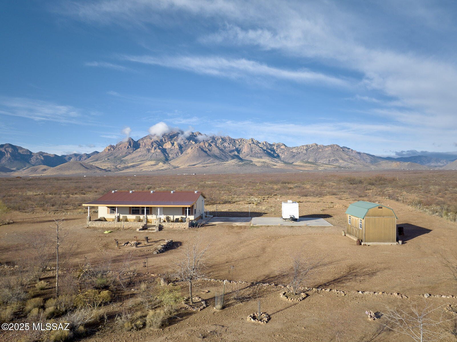 Private 6+ acre retreat with stunning mountain views and no HOA! This well-maintained, move-in ready 1,344 sq ft home offers 3 bedrooms and 2 baths on a permanent foundation. Metal roof installed over shingles for added insulation. Relax on the welcoming porch with rock wall accents added in 2017. Fully fenced parcel with field fencing and walk-through gate on the east side--bring your horses and enjoy wide open space. Large concrete slab with studs north of the home is ready for a hobby shop, garage, or guest house. 12x16 storage shed conveys. Located near Portal, AZ, known for dark night skies, incredible biodiversity, birding, and dramatic mountain scenery. Seller will consider offers including furnishings.