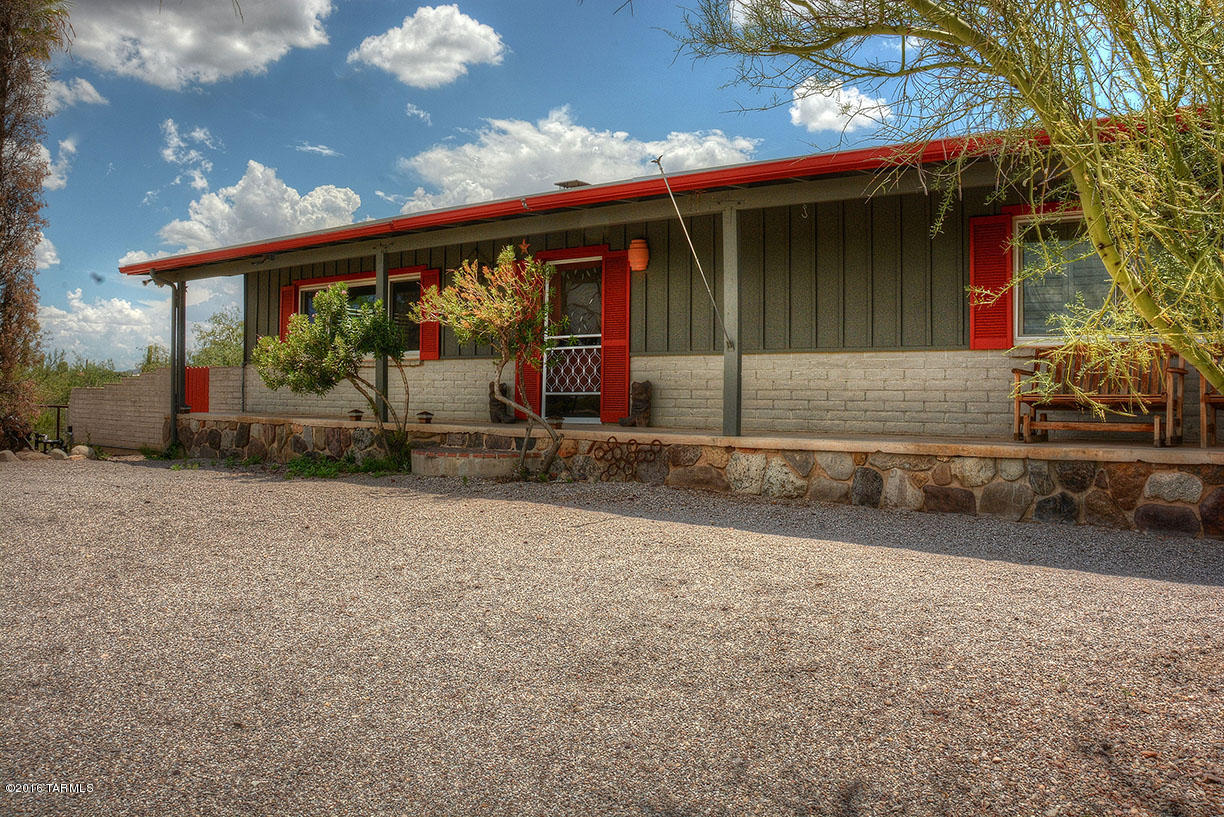 This remodeled & upgraded home has so much to offer! Sitting high on a private, vegetation-studded, 5 acre lot with super city & mountain views! Polished concrete & tile floors thru-out, open kitchen w/granite tile counters & Stainless Steel appls, charming 2-sided brick firplc, TRIPLE PANE windows for max energy efficiency, plantation shutters, & a HUGE Rec Rm/Den/Playroom that could function however you want-including as an addl bedroom. Enjoy the views from Front & Back cov'd patios or relax by the sparking pool/spa. Sport court adjacent to house, Horse Corral & Barn sit just a short walk away in back of the house.
Only minutes to downtown or the U of A.
New roof in 2011, brand new pool equipment and kitch refrig in July 2016.
A great value! Note: Floor Plan in Photos & under Documen