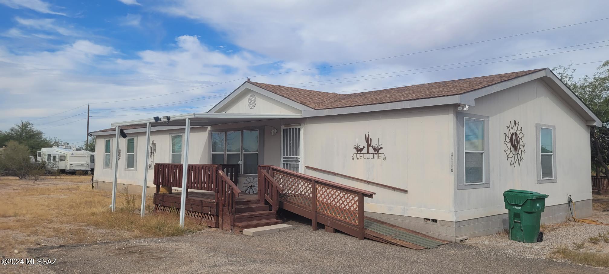 Room to Roam in this flowing home that boasts separate living areas, HUGE kitchen with LOTS of storage and PANTRY! Covered Front and Rear Decks! Block Skirted! Gazebo! 2 storage sheds! 2 Car Carport! Live the peaceful quiet rural life! Close to Pinal Air Park, Circle S Restaurant and VFW! Off Paved Road!