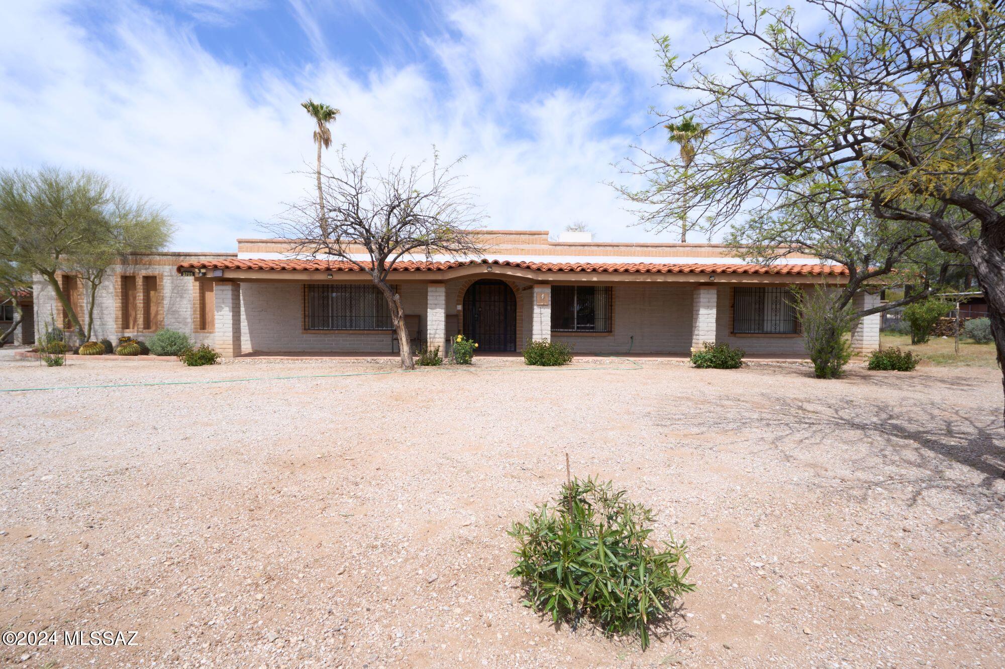 Beautiful NE property with Catalina Mountain views. Lot sits high above the road for privacy and views. Solid block home with a full-length front porch is ready for your personal updates. The big work has been done for you with new HVAC 9/2024, Roof maintenance with a 2 year warranty. kitchen cabinets and granite countertops done in approx 2010. Main house 2092 sq ft with 4bd and 2ba large formal living area and a large family room with fireplace off kitchen. Hall bathroom has been updated with a double vanity and jacuzzi tub. Enjoy your back yard through a screened in porch or sitting around the sparkling pool. Guest home 1050 sq ft 2bd 1ba was built in 2004. GH is currently being rented until 10/31/24 for $1500 per month. Guest home has a full covered patio and a tandem 2 car carport. Managed by Berkshire Hathaway and has a had a history of long-term tenants if buyer was to choose to use as income property.