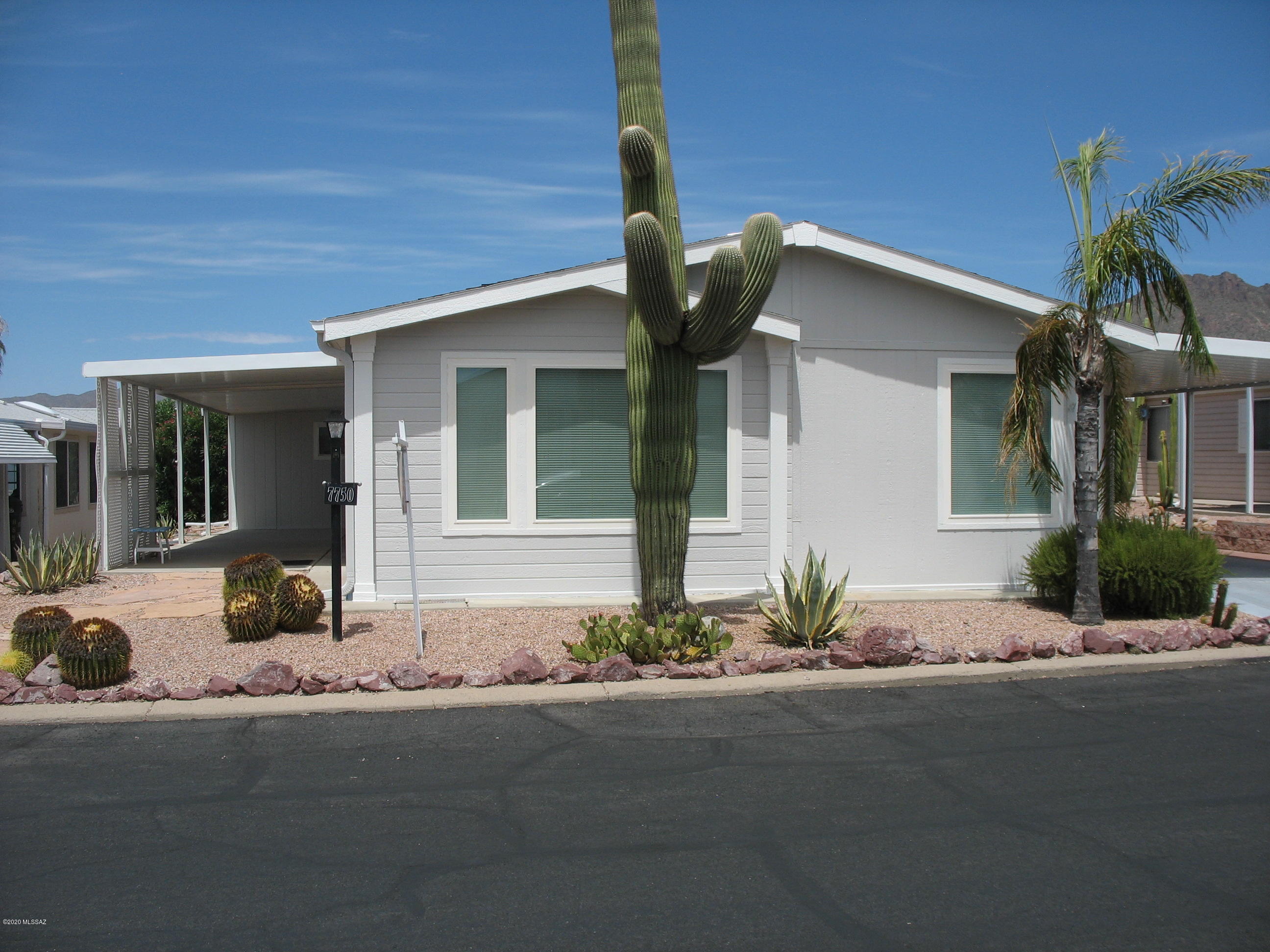 Must see well maintained home in this gated community including renovated large kitchen that is open to the dining area and living room.  The large kitchen has extra cabinets and granite counters.  This home is truly ''move-in'' ready.  Newly installed laminate flooring in living room and dining areas.  Newer carpeting in bedrooms.  New roof in 2014.  Fresh paint inside and outside.  New sink with granite counter top, vanity, and flooring in hall bath.  The carport on the east  side includes an AZ room and a 11 x 20  covered patio with tile floor.  West side of home includes a 10 x 34 covered patio and a 10 x 10 workshop.  The laundry room includes a folding table and extra cabinet space. Seller will assist with closing costs with full price offer. Copper Crest is a gated 55+ Active Adult Community which includes swimming, spa, shuffleboard, pool table, work-out facility, hiking and biking, and more. And, all within a short distance of Tucson.  And you own the land!