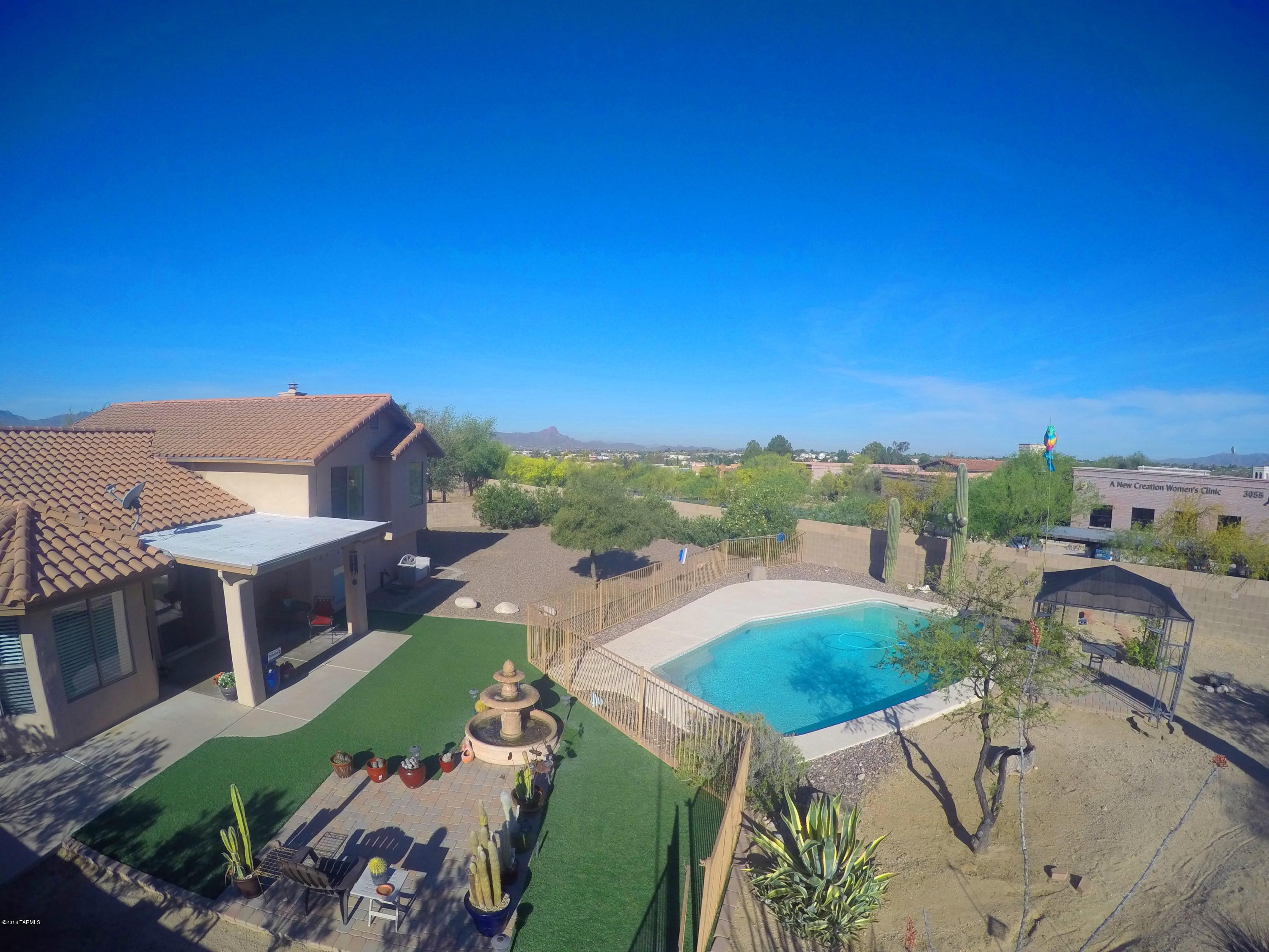 Located in desirable Casas Adobes Terrace. This home offers vaulted ceilings, 2,322 square feet and includes 5 bedrooms (split floorplan), 3 full bathrooms. Kitchen with breakfast bar, living room, dining room, laundry room and pantry on main floor. Don't miss extra large family room downstairs with fireplace.  Finished 2 car garage. Features: Stainless steel appliances, Quartz countertops, ceiling fans throughout, tile on main floor, gas fireplace, and alarm system. Enjoy the best of Arizona outdoor living in the enormous walled in yard with fenced in pool surrounded by cool deck, gazebo, covered patio, fountain, Syn-Lawn and mature low care landscaping with saguaros.Convenient to I-10, the Oracle and Ina Corridors, Foothills Mall, restaurants, entertainment and Northwest Medical Center.