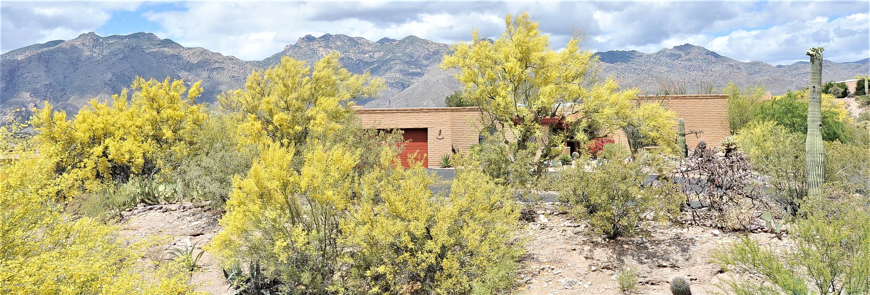 When you decided to move to Tucson, you dreamed of a sweet desert home just like this.  Solid Territorial-style burnt adobe construction. Monterrey tile floors. Saguaro-rib cabinets. Abundant natural light. Wrap-around North-facing porch, plus South-facing dining ramada. A sparkling pool & spa. Lots of desert flowers, trees & cactus on a secluded lot. Yet only two miles to Whole Foods, some great restaurants & Tucson Basis North, one of the top ten STEM high schools in the U.S. Of course, number one on your wish list was an amazing, unobstructed mountain view. You're not dreaming. It's all here. Perched high on the ridge, you will marvel at the ever-changing colors of the Catalina Mountains & gorgeous desert sky. Quiet neighborhood streets encourage walking, running & biking. Welcome home.