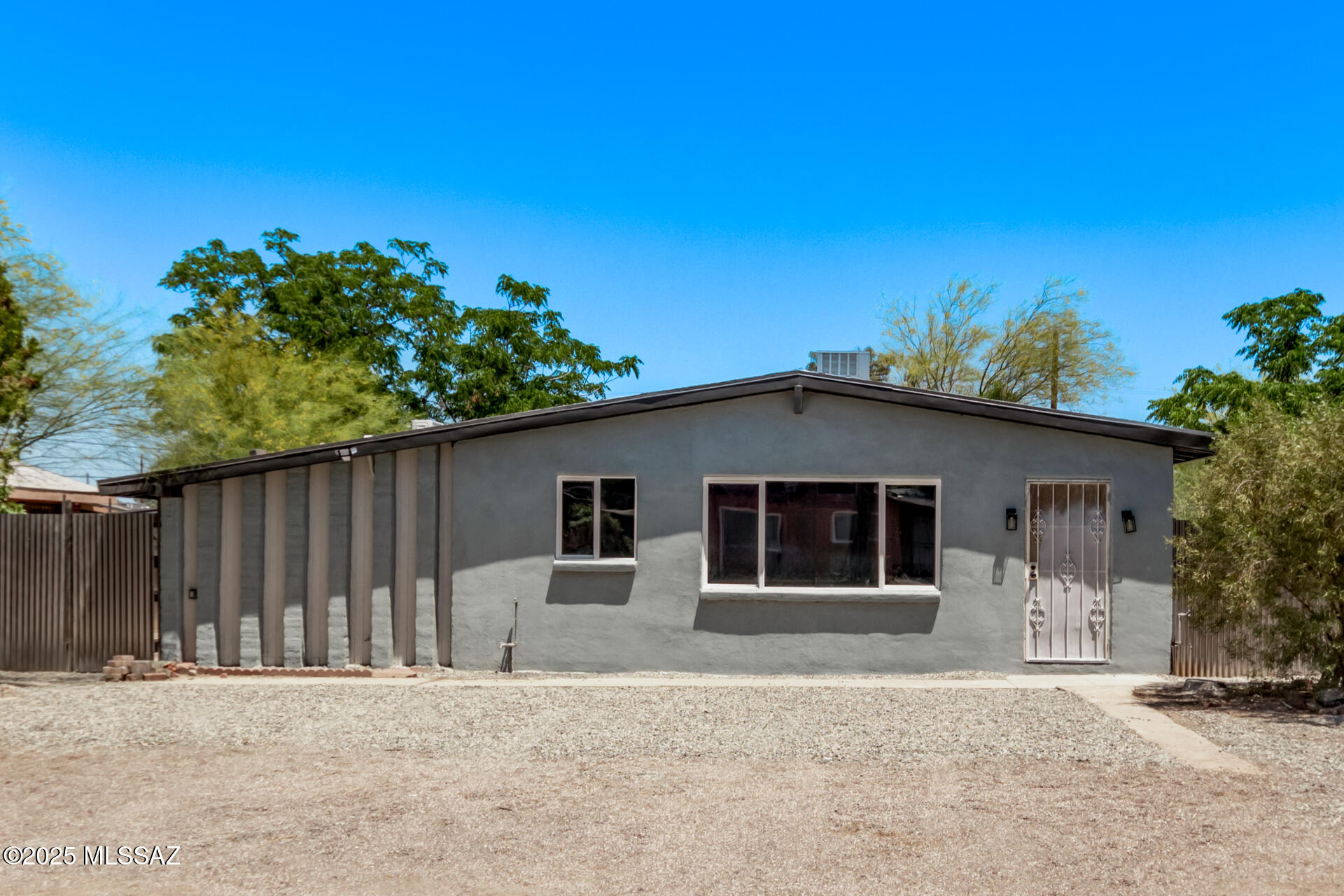 Charming Home with Modern Upgrades Near UofA! Full of character and style, this beautifully renovated home blends classic Tucson charm with modern comforts. Featuring new laminate wood flooring throughout, vaulted beam ceilings, and skylights that flood the space with natural light. Freshly painted inside and out, the home feels clean, bright, and welcoming. A versatile bonus room offers washer/dryer hookups and a wall-mounted portable AC unit. Ideal as a hobby space, or flex room. The kitchen shines with granite countertops, pantry cabinet, gas range, microwave, and fridge. Spacious living and dining areas feel open and inviting, with large windows and central AC for year-round comfort. Relax under the covered patio and enjoy the fully fenced backyard. New HVAC and Windows.