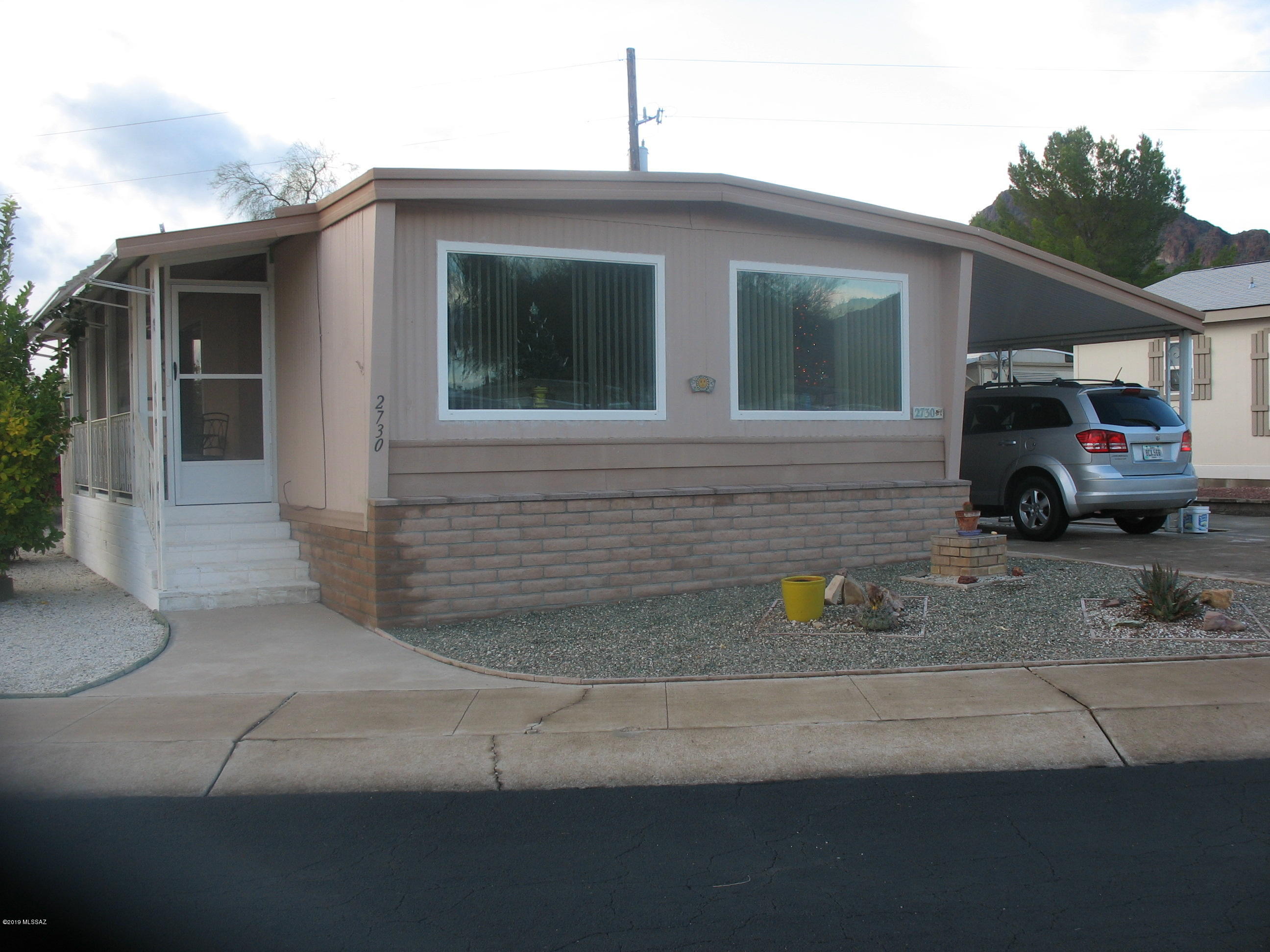 Very nicely maintained home close to the golf course with fantastic views out the living room windows!  Fabulous knotty pine cabinets in extra large kitchen with lots of storage and large island.  Recently installed wood look vinyl flooring.  Home includes double pane windows, recoated roof in last 2 years, and open 10 x 15 Arizona multipurpose room.  Large workshop/storage behind carport and a large second shed.  This TE Community is adjacent to 44,400 acres of Parkland (Tucson Mountain Park/Saguaro National Park West) with more than 68 miles of hiking, biking & equestrian trails.  The HOA fee includes unlimited golf, tennis, pickle ball, shuffleboard, 3 pools, spa, exercise room, trash collection, and a lot more.  You own the land!