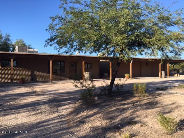 Looking for something unique?  A taste of the wild west in a private setting yet close to it all? This is it!  Quaint adobe classic ranch home on 1.5 acre SR lot.  Original home was remodeled and expanded, but retains the rustic feel. Beamed ceilings and functional stone fireplace.  Fantastic 30 x 34 3 car garage is evaporative cooled and includes spacious workshop area. Extra storage shed on the property plus a tack room and fenced area for horses. Water catchment tank for watering the plants.  Exterior of home & garage stuccoed and recently painted. Lush desert vegetation and cacti.  Fenced rear yard.  Windmill is included.  Don't miss this one of a kind gem!