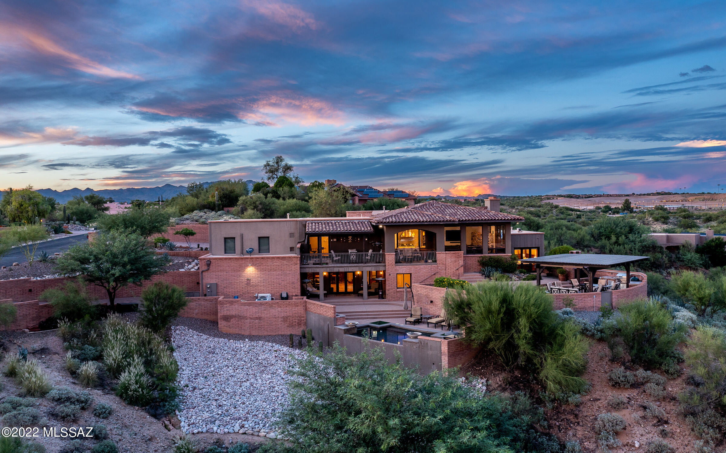 Surround yourself in new heights of luxury at this stunning Contemporary home. Situated on a hilltop, you will enjoy the immense mountain views & sparkling city lights. Completed with impeccable materials providing a combination of textures, finishes & a warm palette of unmatched architectural mastery. The dedicated living spaces include a spacious great room with over the top mountain views, den with SubZero 147 bottle wine cooler plus a  generous guest quarters/flex room downstairs. The gourmet kitchen, perfect for any chef, boasts an oversized center-island, high-end SS appliances & walk-in pantry. Primary suite finds a cozy fireplace, lux bath & custom closet. Outdoor opulent living has an Argentine grill, Wolf 42''BBQ, Ramada with a gas fire pit, negative edge pool & many covered patios. Added bonus feature is the 4.5 car garage & tons of storage.