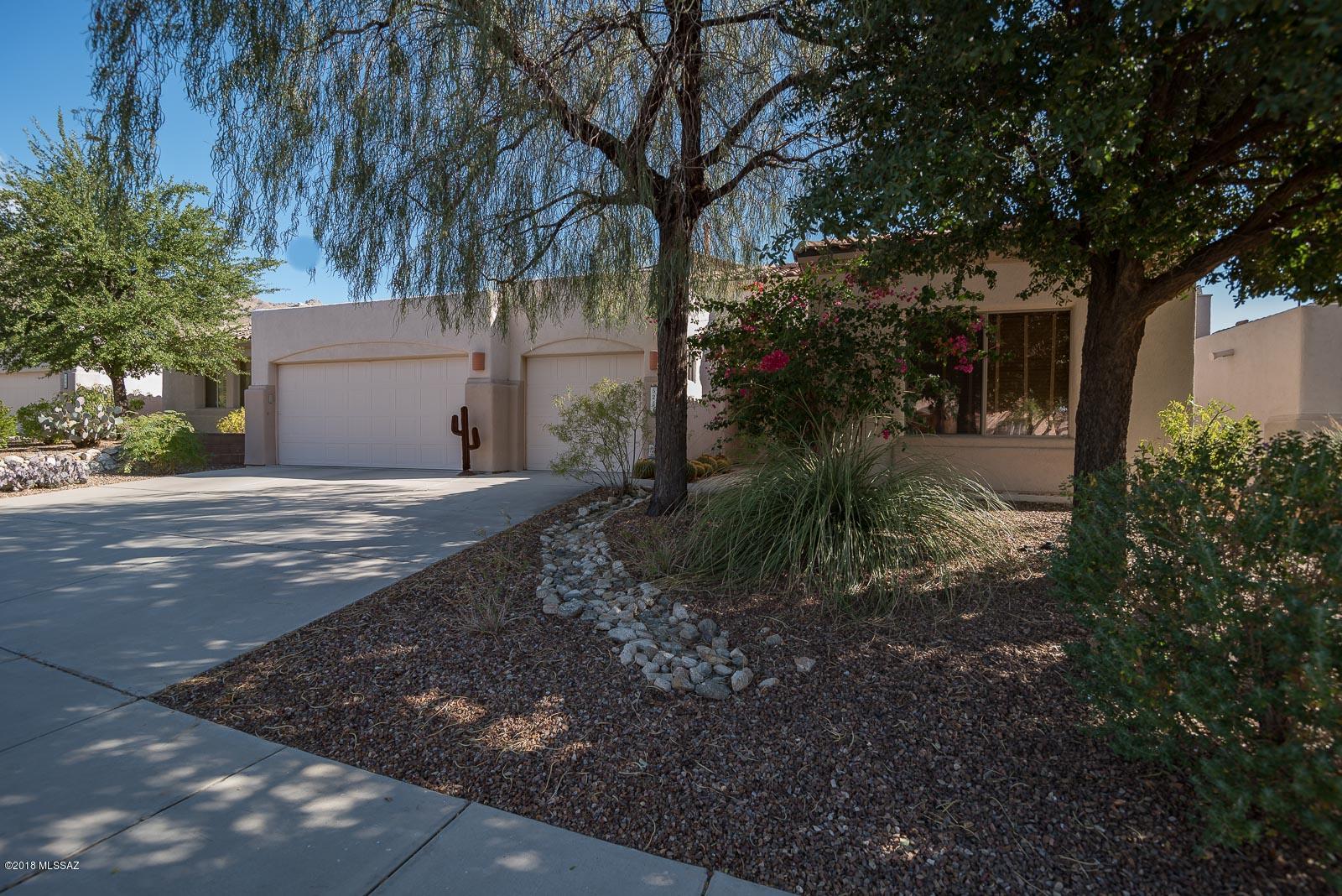 Gorgeous mountain views from this wonderful property in gated Sabino Springs, home to AZ National Golf Course. Large 2,323 sq ft with 4 bedrooms, 2 1/2 baths plus 3 car garage. Full of upgrades with 24'' travertine floors, granite counter tops, tile backsplash, custom paint, classy office with built ins and Murphy bed, just to name a few. Cathedral ceilings with formal living/dining with cozy fireplace room plus family room off open and upgraded kitchen. Beautifully landscaped back yard that is extremely private and next to the fairway plus pebbletec pool, built-in BBQ and hot tub, perfect for entertaining!