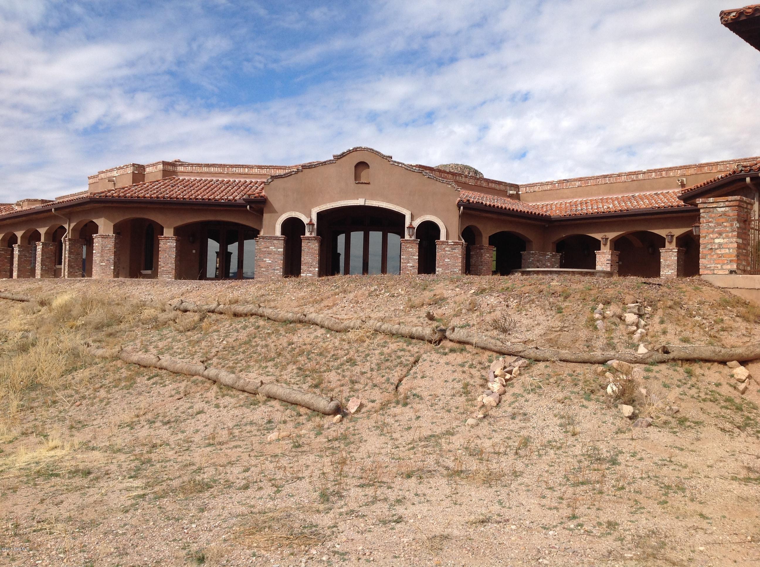 This Hacienda home is one of a kind with recycled wood, brick, and stone. Main house features spacious great room with huge expansions of windows bringing the outside in. Magnificent open kitchen with granite counters loaded with cabinets, counter space, pantry, high-end appliances plus a butlers kitchen with 2 refrigerators, and coffee service. Den with built-in desk and cabinets, wine cellar, temp. controlled closet off master, there is also an art studio with bath, guest house features great room, full kitchen, two bedroom and two baths, private patio. Expanse of covered patio with outdoor kitchen, fireplace, 3 car garage + RV garage, custom paint, tile cabinetry, this home has many possibilities. Move in ready and waiting for the buyer who wants privacy, space, and views.