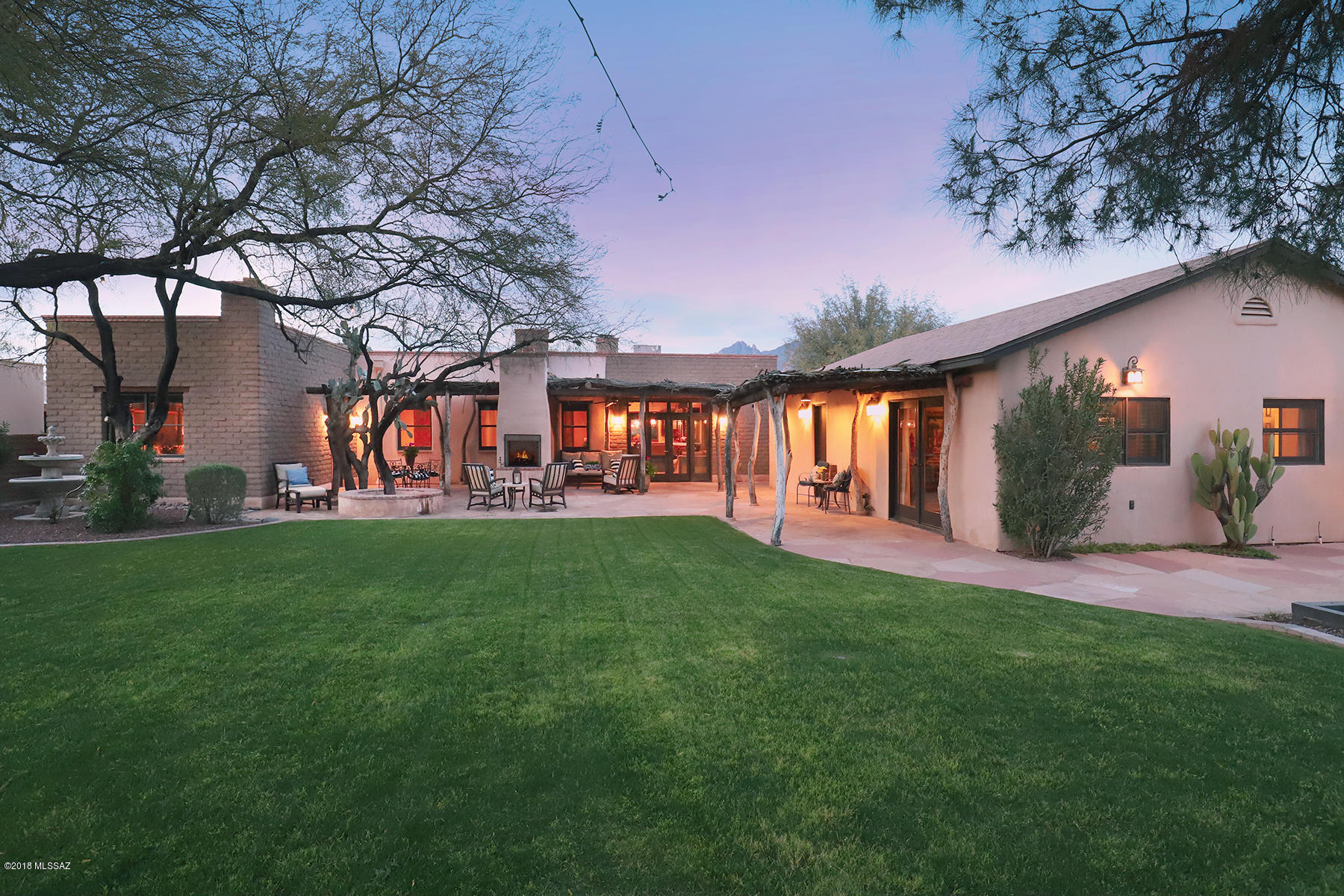 Welcome to a warm, gracious one-of-a-kind custom and elegant abode nestled in a beautiful street of Adobe homes as only Tucson can do. The home shines as an example of how thoughtful and creative artisanal construction and re-purposing can create an oasis in Central Tucson, a luxurious and sophisticated handcrafted 2636SF adobe home plus a 384SF casita that reflects that magical merging of inspiration and architecture. This masterfully designed home, located in desirable mid-town just minutes north from downtown, UMC, and UofA sporting events and south of the Foothills fine restaurants, includes all modern luxury amenities, plus a large terrace and rear yard that allows for delightful outdoor living and entertaining. With high-end custom finishes throughout, be sure to note the integral-colored massive adobe walls, ceilings finished in reclaimed vigas (beams) and latillas (wood strips) from an old Wisconsin barn, and the many antique and well-selected chandeliers found throughout the home.

Enter through a delightful private gated flagstone courtyard with ivy-covered walls, through the craftsman style glass and metal artisan-designed front doors, and into the entry foyer, defined by four intricately hand-carved columns from 1880's colonial India. Ahead is the dining room, with views of the lush rear yard and a wood-burning gas fireplace, one of four in the home. Left is the kitchen, a magnificently designed gourmet and gathering spot, featuring custom hand-created cabinetry and handsome bullnose granite surfaces. Appliances are a 48" Wolf double oven range with six burners and a griddle, and built-in Thermador fridge/freezer, dishwasher, warming drawer and microwave. An oversized Shaw's farmhouse ceramic sink, flanked by two matching chandeliers, fits perfectly in the kitchen. The large hand-stained island can seat 5 guests who can chat with the chefs comfortably and includes a copper bar sink and specialized storage for trays/cookie sheets. Another bar area provides seating for 4-6 people. Nothing was overlooked in this kitchen-note the pull-out spice columns next to the cooktop, pot-filler, and pull-out storage cabinets. Plenty of room for the whole family and guests to gather! The adjacent warm and cozy family room enjoys a custom built-in entertainment center and opens to the rear yard, an oasis of lush grass defined by ancient mesquites that canopy the back yard and gorgeous mature desert specimens rarely seen in Tucson homes. Flagstone terraces are covered by a custom patio cover of mesquite beams with ocotillo ribbing. A double-sided fireplace defines two comfortable conversation areas. Adjacent to the rear yard is the casita, with a living area that includes kitchen amenities including a wine and beverage fridge, a bedroom and beautiful full bath. And while you're in the rear yard, peek around the corner for the chicken coop, fully automated and custom-designed with 2 chandeliers (no kidding!) indoor/outdoor living and formerly home to six Silkie chickens. (The latest hot item for upscale homes in Silicon Valley!) A large driveway area has been home to taco/churro trucks for many parties, all gated and enclosed for privacy. The current owners recall entertaining up to 80 people with ease and grace. Back inside and to the right of the entry is a lovely guest suite with full bath, an office or small bedroom, another full bath with elegant custom tiling, and a glassed-in wall exposing an original adobe wall from the 1930's that shows the historical roots of the home. The master bedroom area is a romantic suite, with a delicate beehive fireplace, adobe brick walls, another perfect chandelier over the bed and glass doors to the rear yard terrace. A master bath enjoys a free-standing claw-foot tub topped with another fun chandelier, copper sinks set into patinaed concrete, glassed-in shower, and a well-appointed spacious walk-in closet. The home's electgrical system is fully modernized and up to code, the home is wired for speakers throughout, and a water softener and filtration system for the entire home was installed in 2017. Located in a well-maintained neighborhood; a brief walk up the street shows the pride of ownership of neighbors, and their friendliness as well. Equally near to the river walk, U of A, downtown and the Foothills for shopping, entertainment, sports events, dining and medical services. Open enrollment for Catalina Foothills School District and plenty of other families for carpooling. This one-of-a-kind adobe home is described by its current owners as "paradise in Central Tucson", and a visit will show you the accuracy of this description!