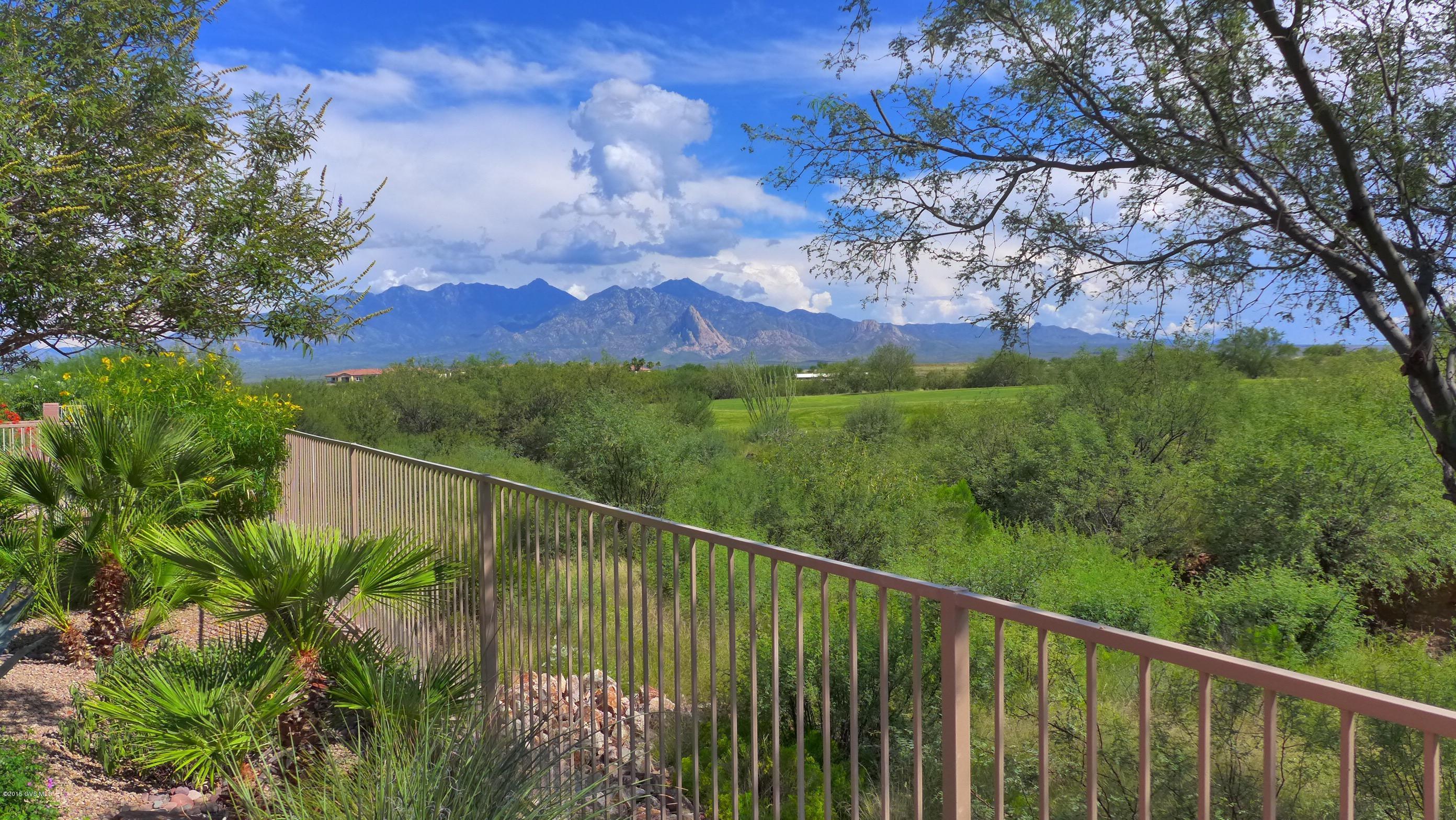 Captivating setting comes with a home that has ALL your I Wants! Situated on the first hole of the Canoa Ranch Golf Course it is surrounded by lush vegetation and boasts a magnificent view of the ever-changing Santa Ritas. Even the most discriminating buyer will be impressed with the countless upgrades in this gorgeous home. Step through the front door and experience love at first sight as your eyes will be drawn to the wall of windows overlooking a slice of Southwest heaven that will make your heart sing. The centerpiece of the great room is a lovely kiva fireplace. There are tile floors in all the right places, a split bedroom floor plan, a gourmet kitchen that cooks & non-cooks alike will appreciate and high-end finishes throughout. The beautifully landscaped backyard overlooks  the golf course and has breathtaking mountain views. You'll be protected from the sun by the large covered patio and stylish pergola. At night slip into the bubbling hot tub and get lost in the dazzling Arizona night sky full of twinkling stars.