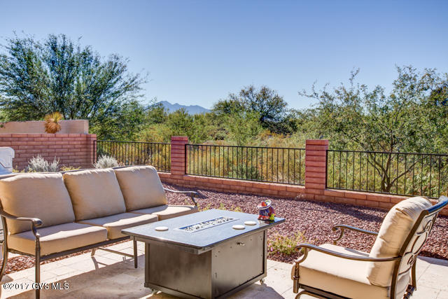 From the moment you walk into this house you know you have entered a very special home! 2 Bedroom, 2-1/2 bath home on an arroyo with Mountain Views & city lights! Exceptional 18 tile, on a diagonal, in all the living areas. The main focal point of the Great Room is a linear electric fireplace mounted on a beautiful, floor to ceiling stacked stone wall. The Great Rm.TV is mounted above the fireplace. The Kitchen has stainless steel appliances, shaker crown molding above the expresso-stained beech cabinets, roll-out shelves, quartz counters, under-cabinet lighting, full-height, tile back-splash & granite composite under-mount sink. The spacious Master Bedroom has crown molding, a walk-in closet & upgraded bath fixtures in the Master Bath. The back-patio features travertine pavers &  faux grass.