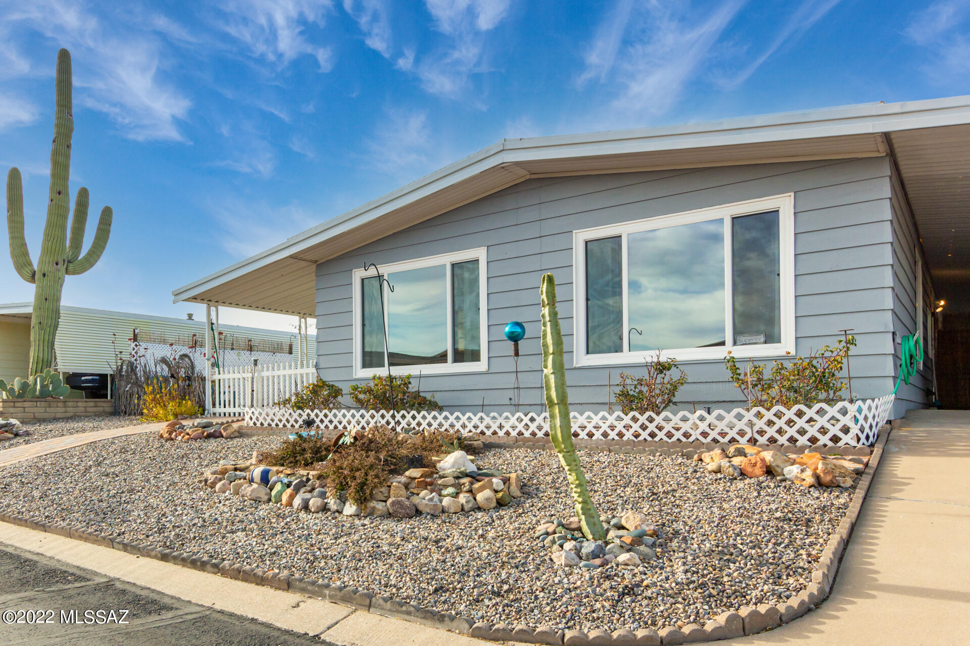 CHARMING home in a 55+ Community with easy-care desert landscape, spacious carport and an expansive side-covered patio! Step inside to a recently updated and upgraded open living room, boasting vaulted beamed ceiling, laminate floors, neutral palette, and huge windows great for natural light. More updates include new HVAC in 2020, sliding barn doors, updated bathroom, ceiling fans, termite treatment and upgraded plumbing by previous owner. The fully equipped, eat-in kitchen has a plethora of white cabinets and lovely pendant lights. The main bedroom showcases a sizable closet and lavish bathroom w/dual sinks, relaxing bathtub, and plenty of cabinets for storage. Large inside laundry with storage and W/D that convey with the sale. Delightful backyard with gorgeous mountain views has several sitting areas, lemon fruit trees, and pavers. You don't want to miss this value. Call now!