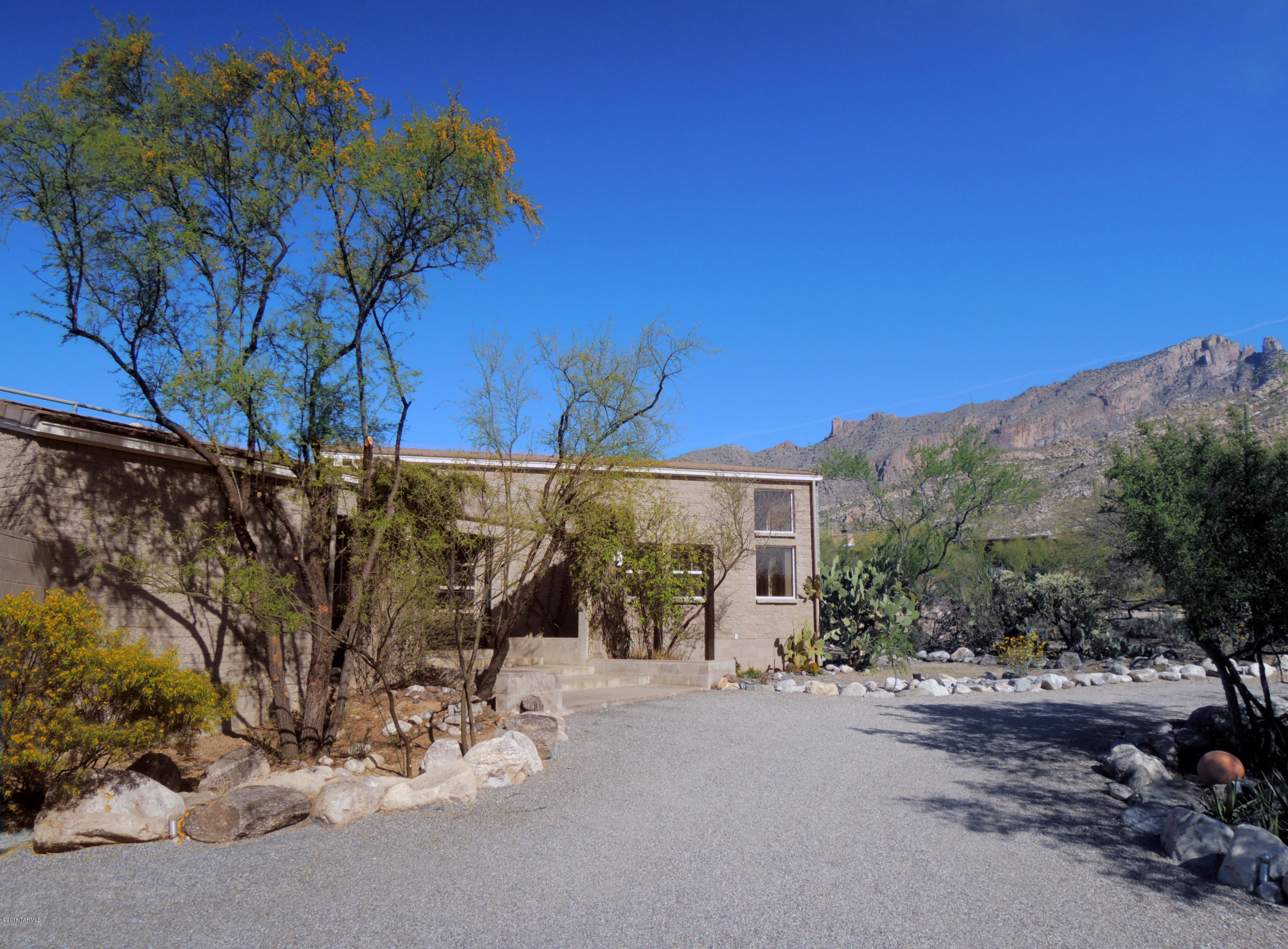 This Custom Contemporary split face block home is Designed to the Desert. Windows create a breathtaking frame of the Catalinas. So Serene & Private! A large covered patio opens to a brick path meandering through a charming shaded garden. It leads to West gate opening to gorgeous Saguaro studded Mtn View land. Expansive Deck affords 360 degree Views. Planked shed ceilings sheltering Liv Rm, DR, Kitchen & Fam Rm, add architectural interest, accenting rooms filled w/ natural light. Striking FP.  Eat-in Kitchen offers extensive granite work space. Master & adjacent Study have Mtn Views. French door opens to a charming interior open air garden. Main house: 3 BRs, 2 Full Baths + Half Bath and 3 A/C + Heat units. Guest House: Kitchen, 2 BRs, Bath, A/C + Heat, planked ceiling & its own laundry!